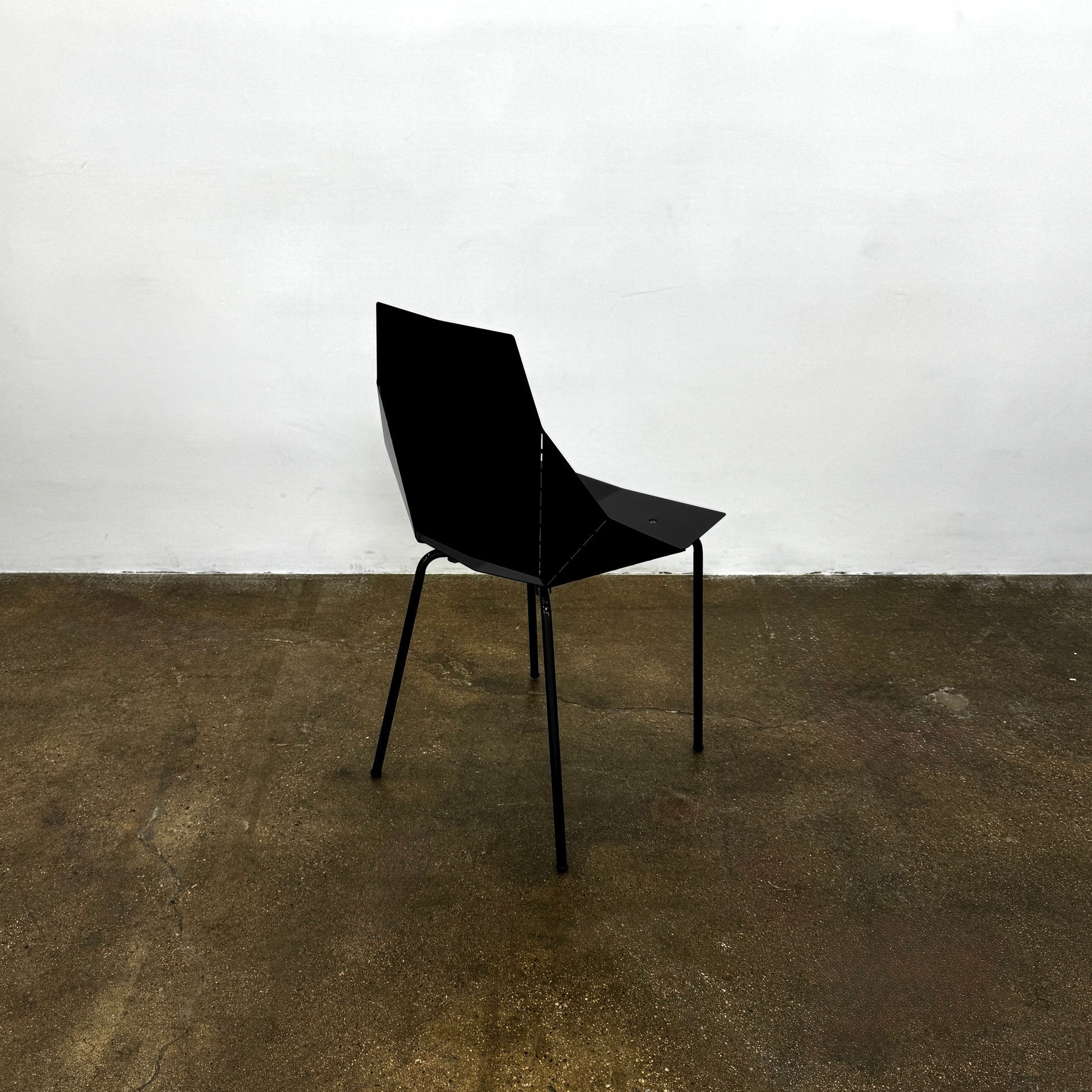 The Blu Dot “Real Good Chair” by Blu Dot is a black, angular steel chair with four metal legs and a powder-coated finish, shown against a plain white background.