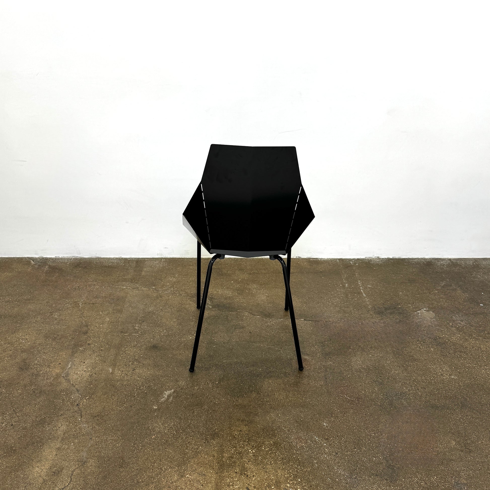The Blu Dot “Real Good Chair” by Blu Dot is a black, angular steel chair with four metal legs and a powder-coated finish, shown against a plain white background.