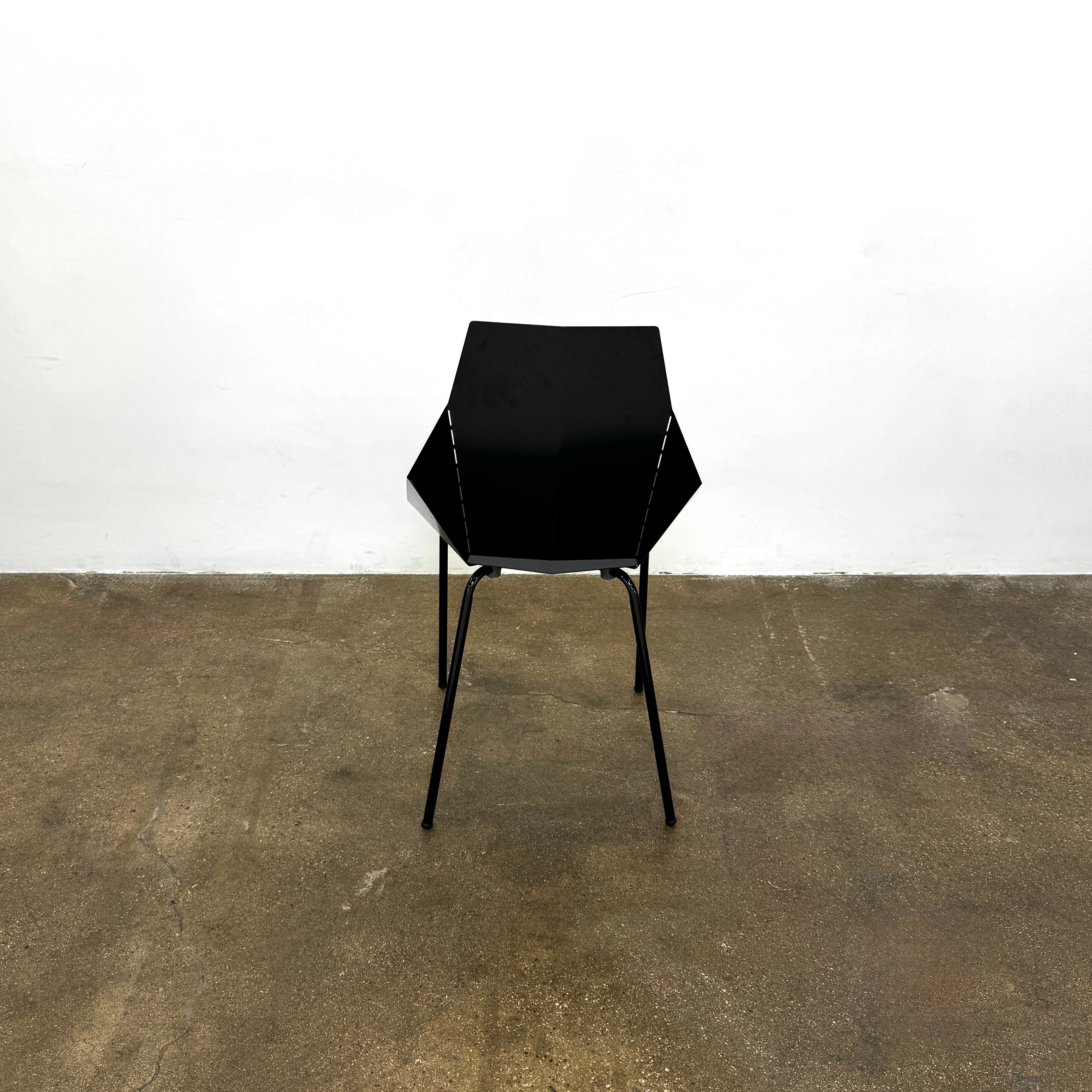 The Blu Dot “Real Good Chair” by Blu Dot is a black, angular steel chair with four metal legs and a powder-coated finish, shown against a plain white background.