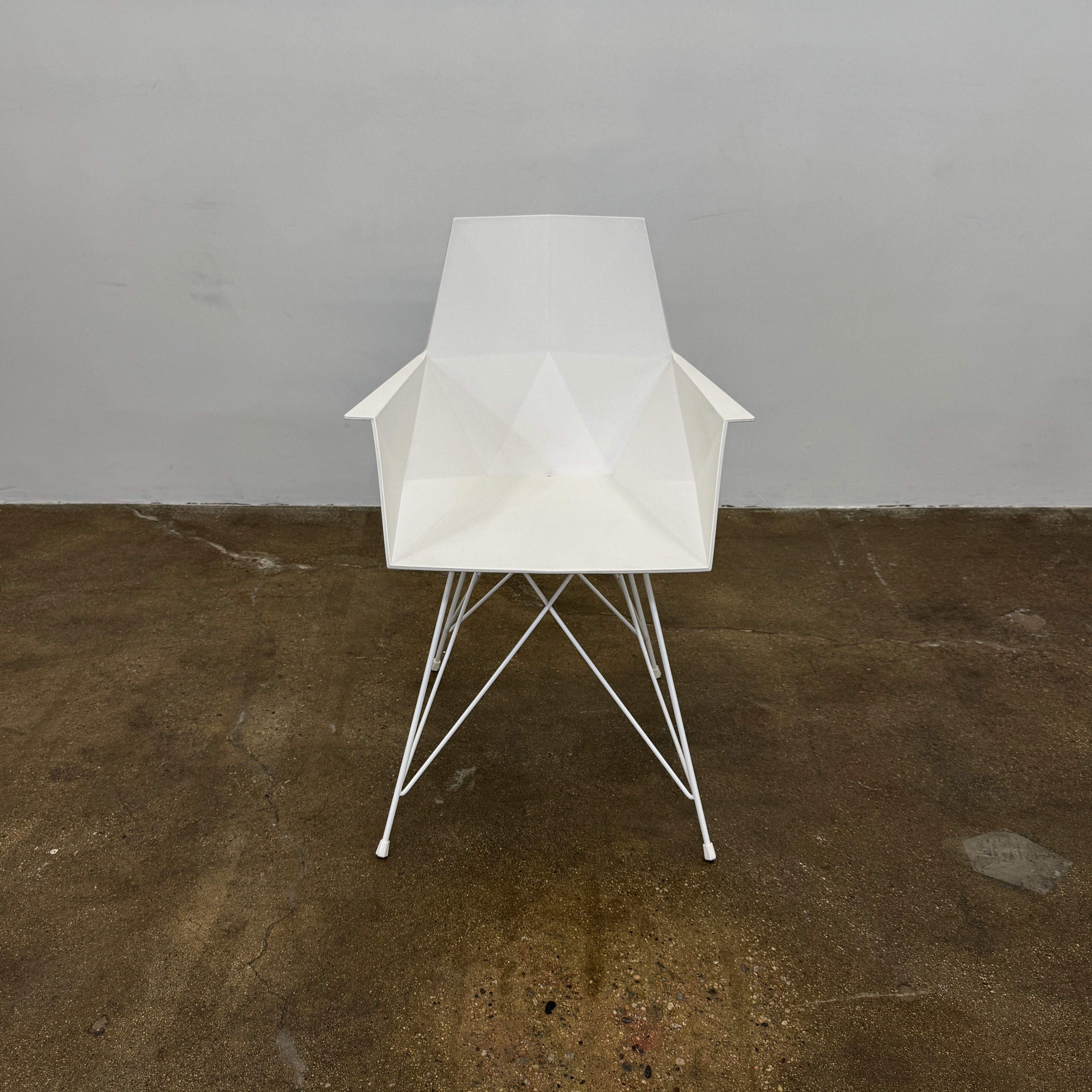 Four Vondom Faz Armchairs with steel bases, designed by Vondom, are arranged in two rows against a plain white background, highlighting their modern geometric style. Set includes four chairs.