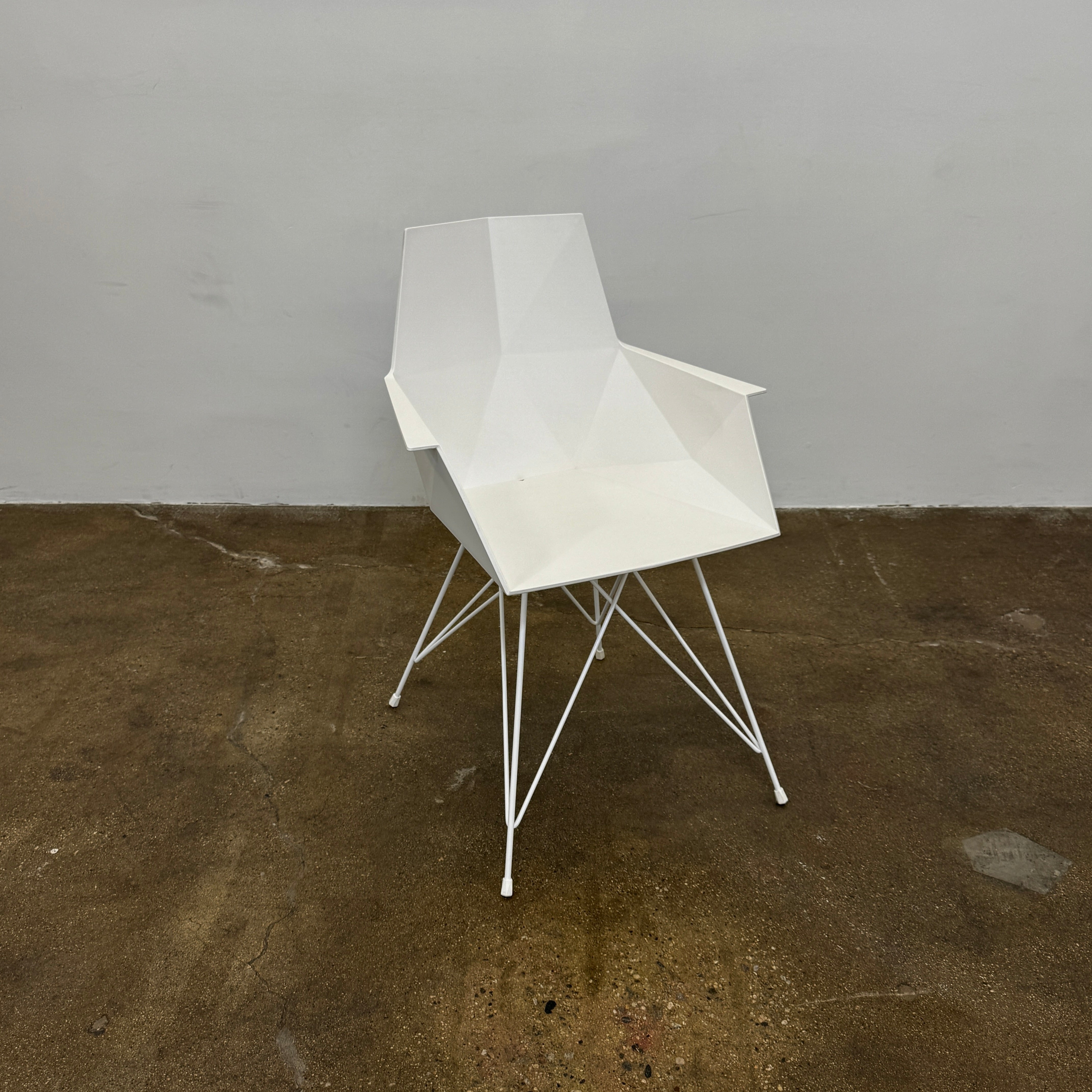 Four Vondom Faz Armchairs with steel bases, designed by Vondom, are arranged in two rows against a plain white background, highlighting their modern geometric style. Set includes four chairs.