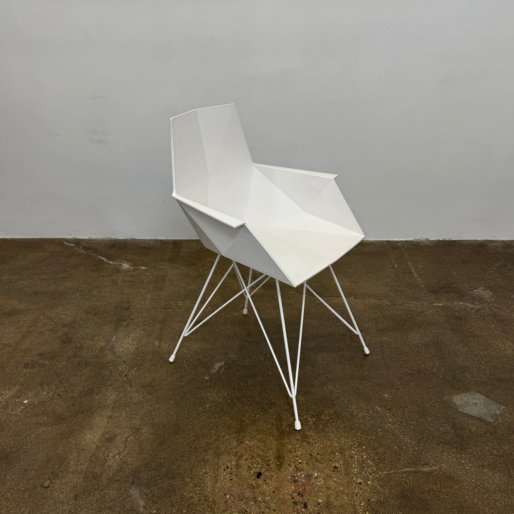 Four Vondom Faz Armchairs with steel bases, designed by Vondom, are arranged in two rows against a plain white background, highlighting their modern geometric style. Set includes four chairs.