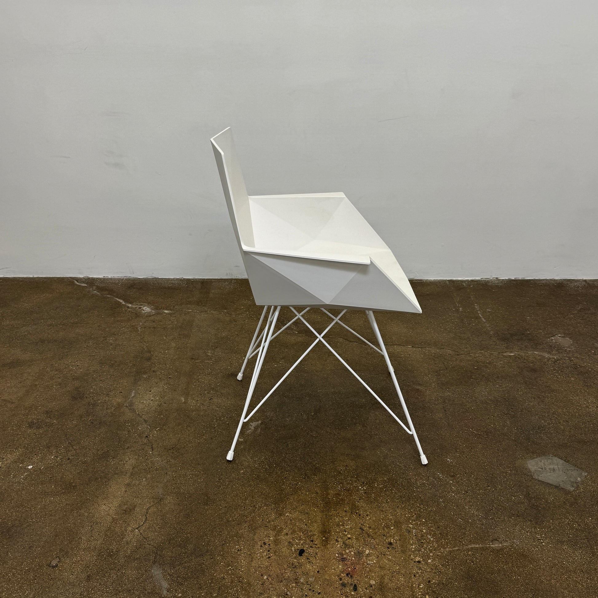 Four Vondom Faz Armchairs with steel bases, designed by Vondom, are arranged in two rows against a plain white background, highlighting their modern geometric style. Set includes four chairs.