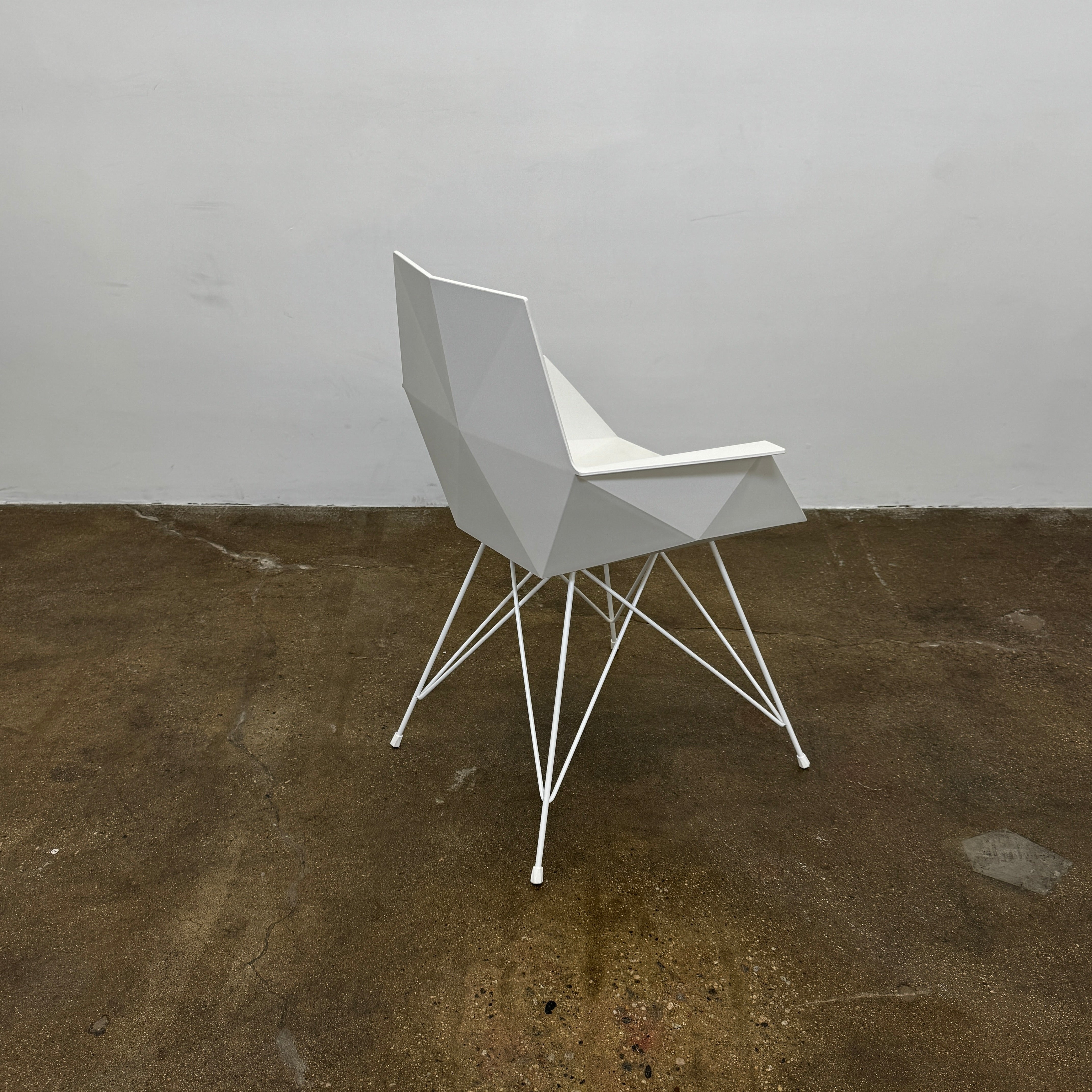 Four Vondom Faz Armchairs with steel bases, designed by Vondom, are arranged in two rows against a plain white background, highlighting their modern geometric style. Set includes four chairs.