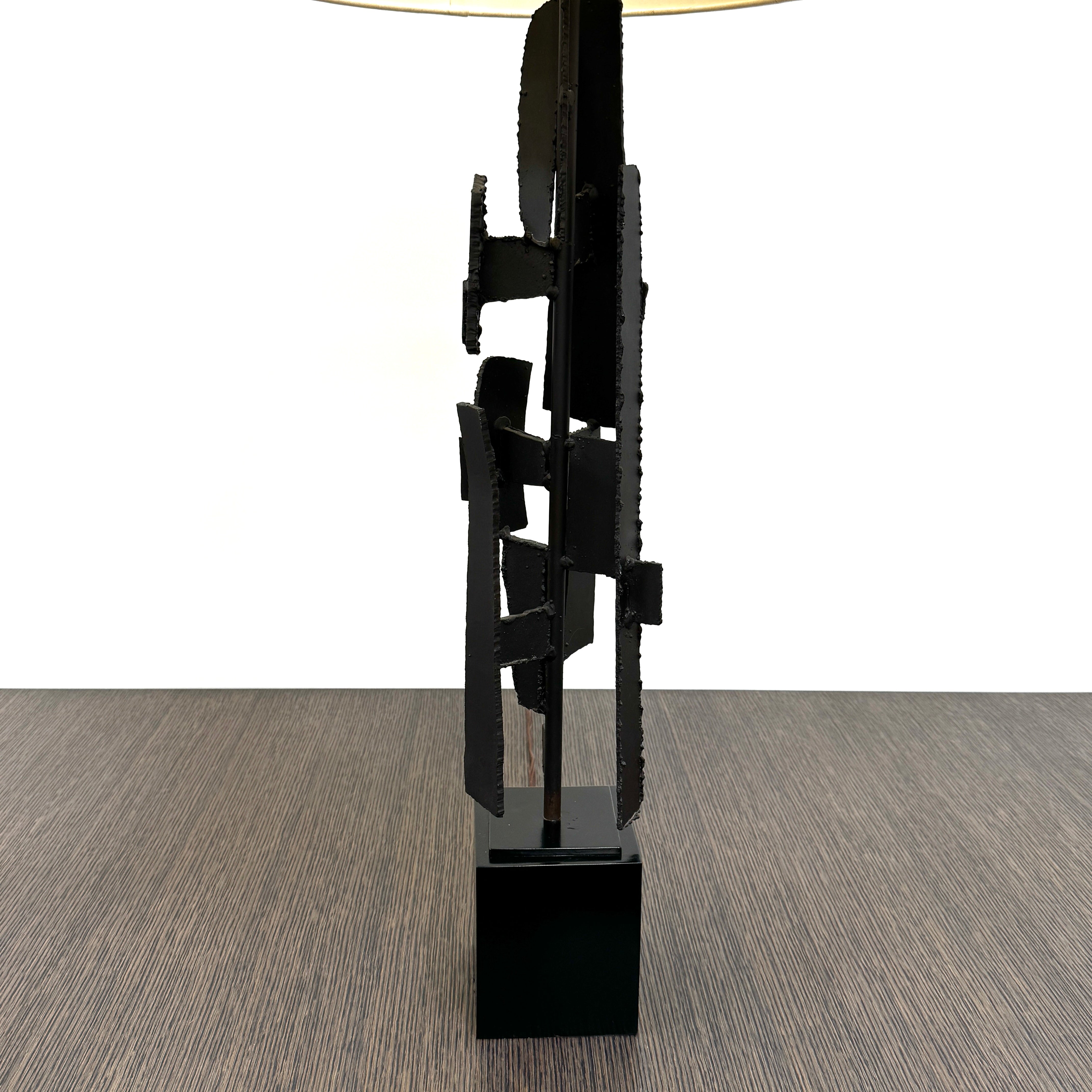 A pair of Vintage Richard Barr Iron Brutalist table lamps for Laurel Lamp Co., featuring abstract black metal bases and cylindrical white shades, set against a plain white background.