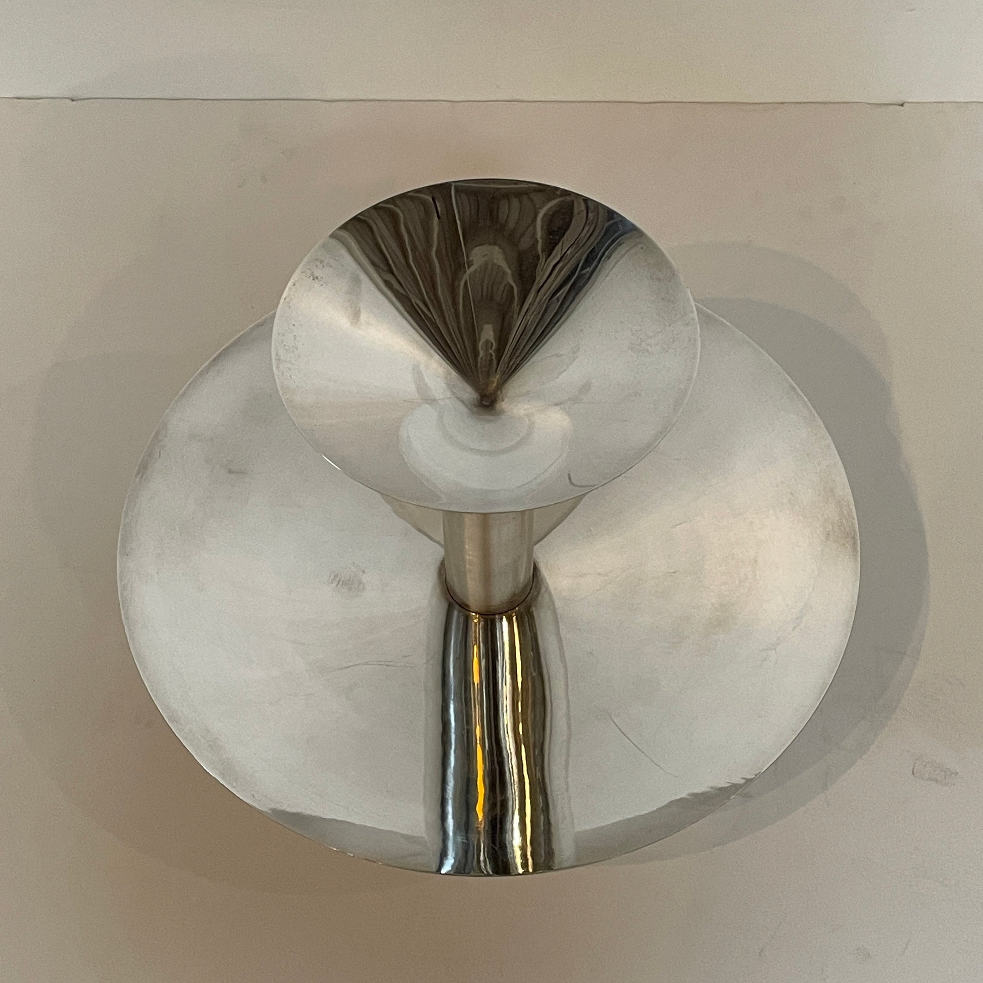 An Enzo Mari-inspired, tiered metal Driade Silver Fruit Stand Centerpiece with a reflective silver finish, isolated on a white background.