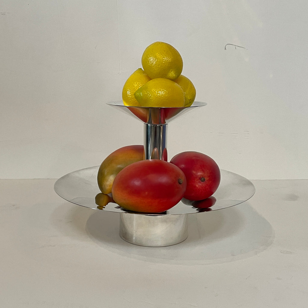 An Enzo Mari-inspired, tiered metal Driade Silver Fruit Stand Centerpiece with a reflective silver finish, isolated on a white background.