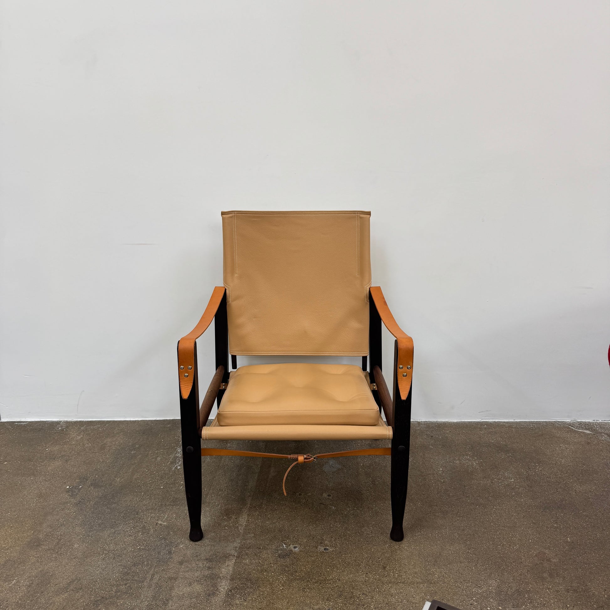 The Carl Hansen & Son KK47000 Safari Lounge Chair by Kaare Klint features canvas and leather with wooden legs and armrests, shown from the front on a plain white background.