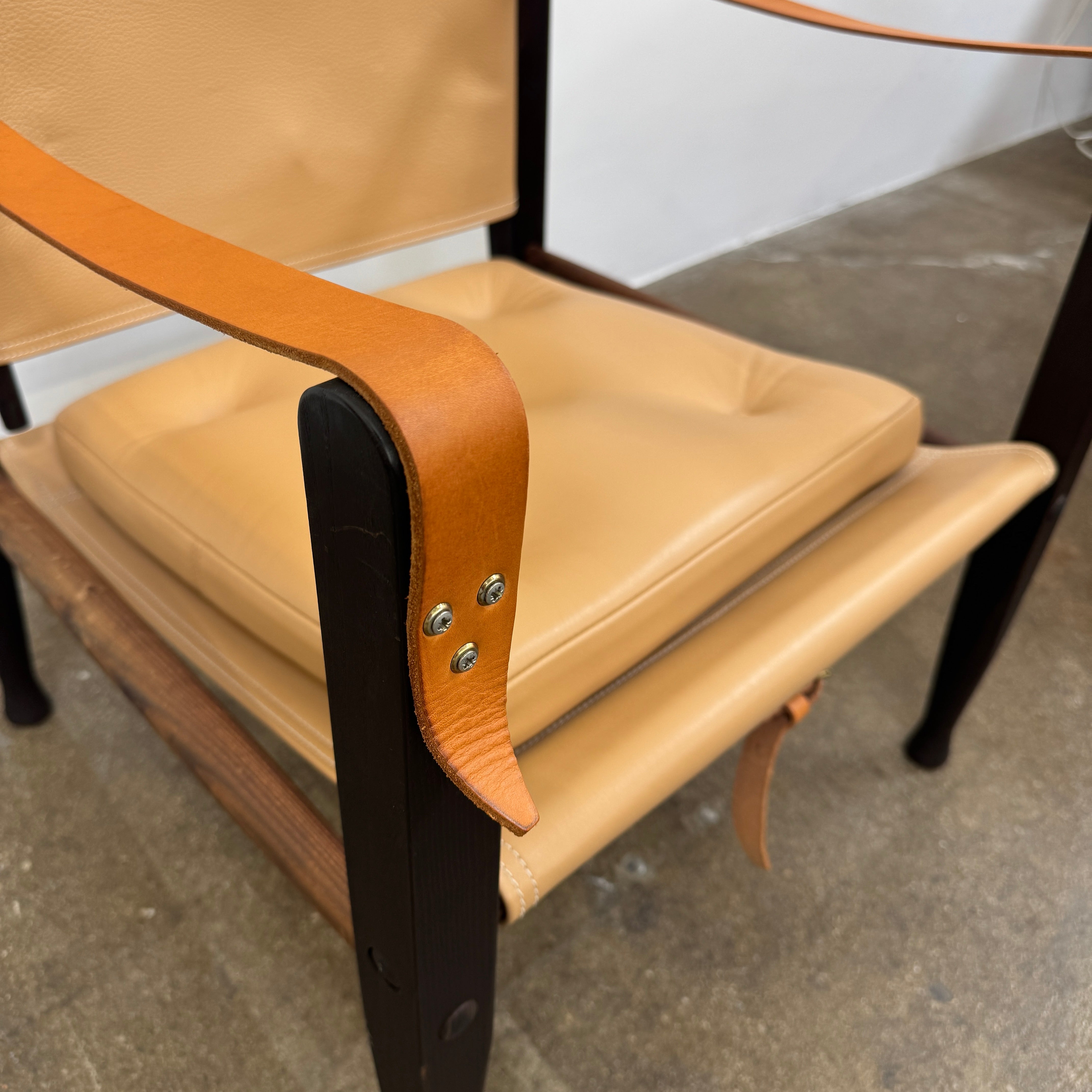 The Carl Hansen & Son KK47000 Safari Lounge Chair by Kaare Klint features canvas and leather with wooden legs and armrests, shown from the front on a plain white background.