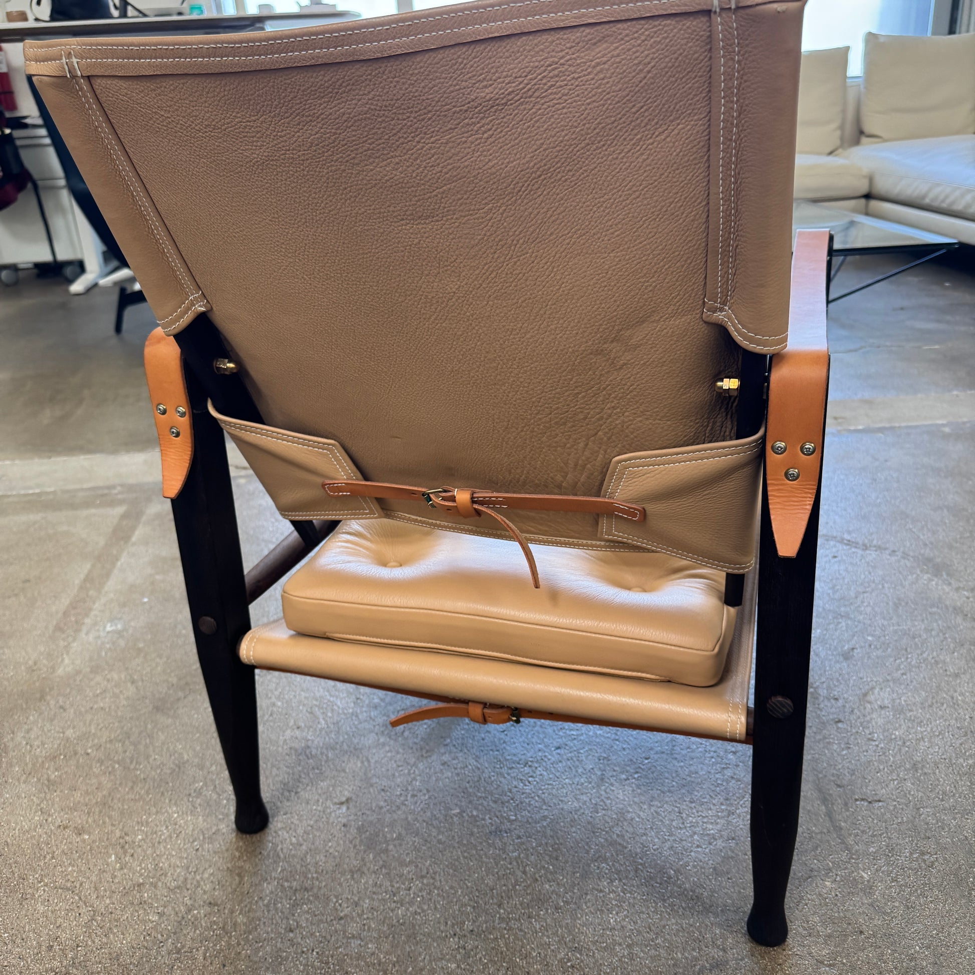The Carl Hansen & Son KK47000 Safari Lounge Chair by Kaare Klint features canvas and leather with wooden legs and armrests, shown from the front on a plain white background.