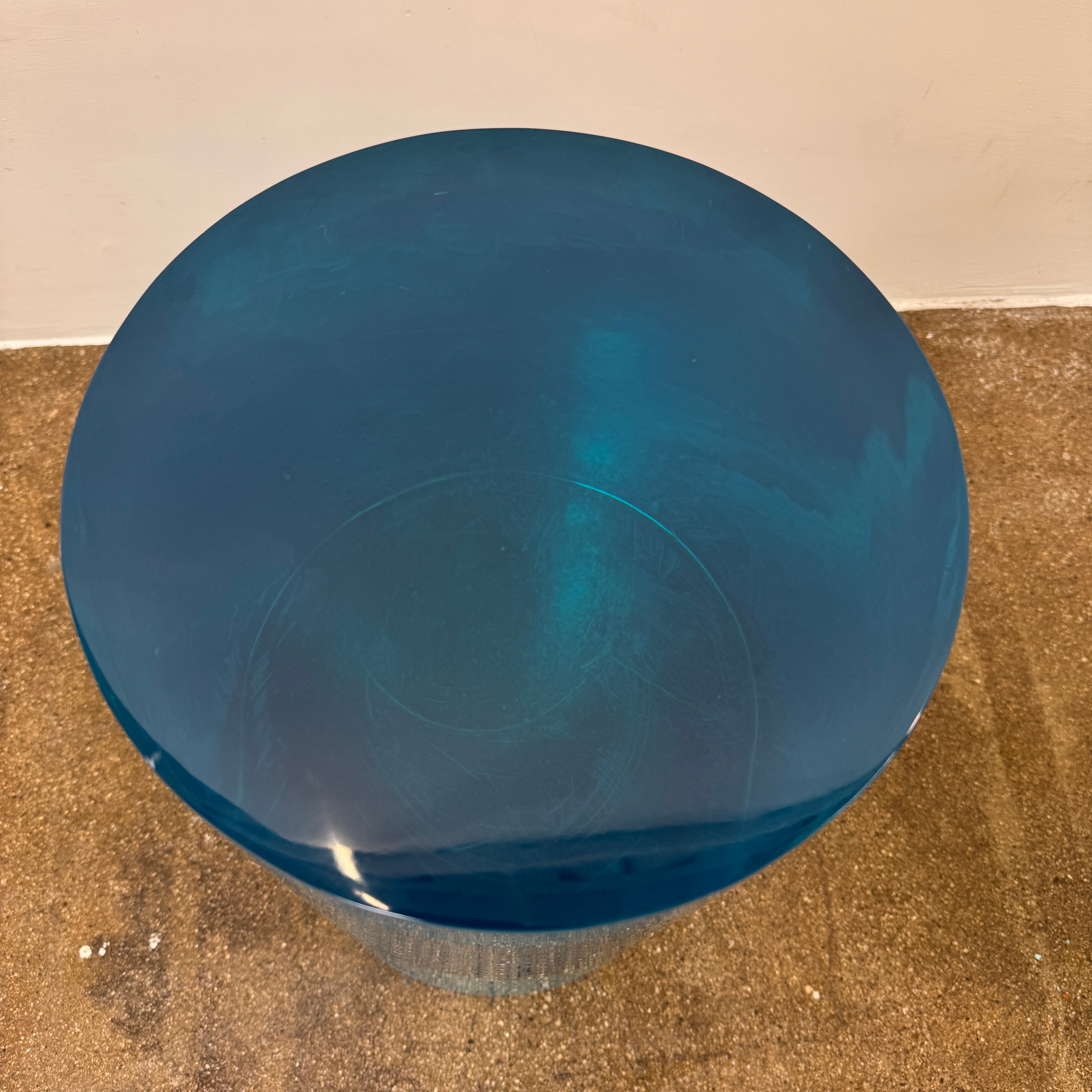 The Jonathan Adler blue acrylic cylindrical table stands upright on a white background, featuring smooth sides and a flat top that evoke the brand’s modern, chic design aesthetic.