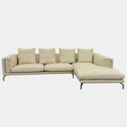 The DWR Como Sectional Sofa by DWR, in beige, features five back cushions and metal legs, showcasing Italian designer inspiration against a white background.