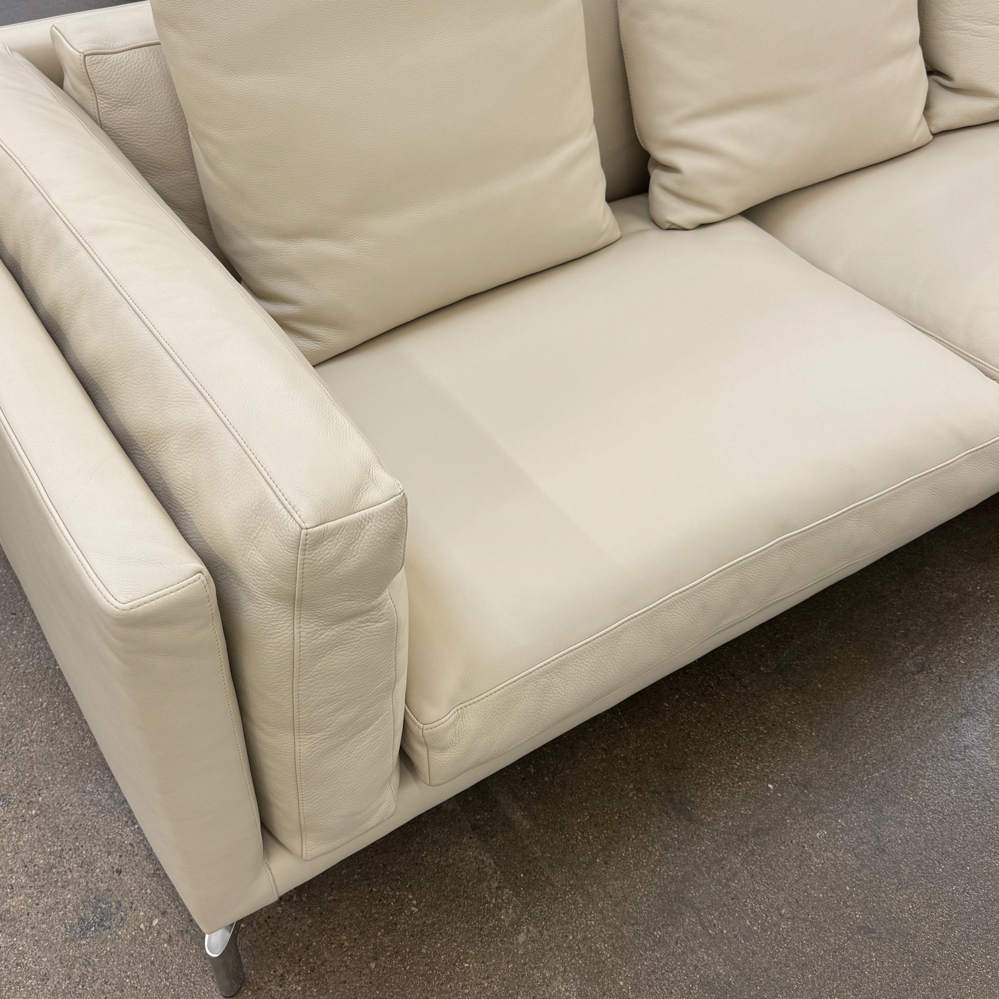 The DWR Como Sectional Sofa by DWR, in beige, features five back cushions and metal legs, showcasing Italian designer inspiration against a white background.