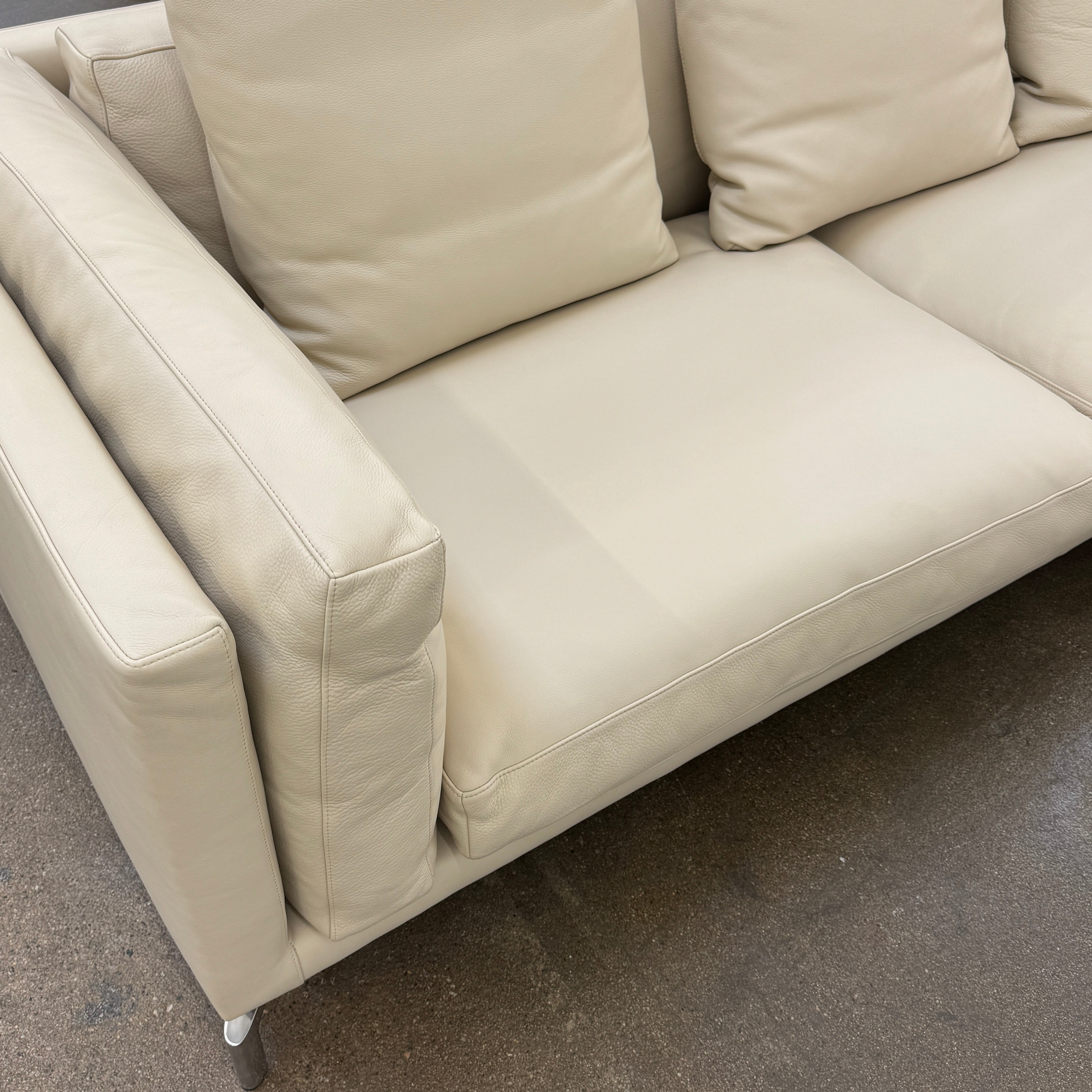 The DWR Como Sectional Sofa by DWR, in beige, features five back cushions and metal legs, showcasing Italian designer inspiration against a white background.