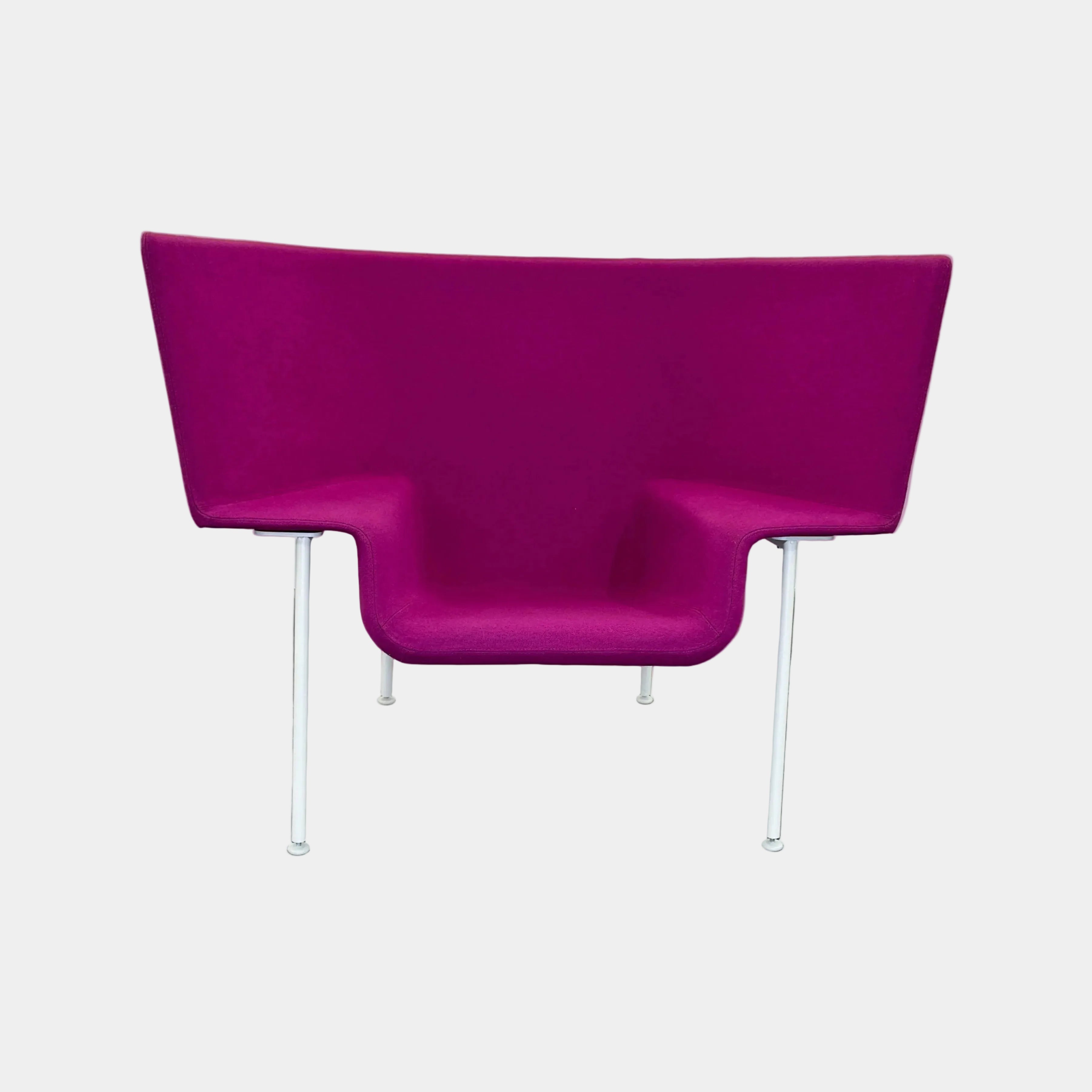 The Cappellini Capo Chair by Cappellini features a modern design with bright magenta upholstery, an angular backrest, and white metal legs, set against a plain white background.
