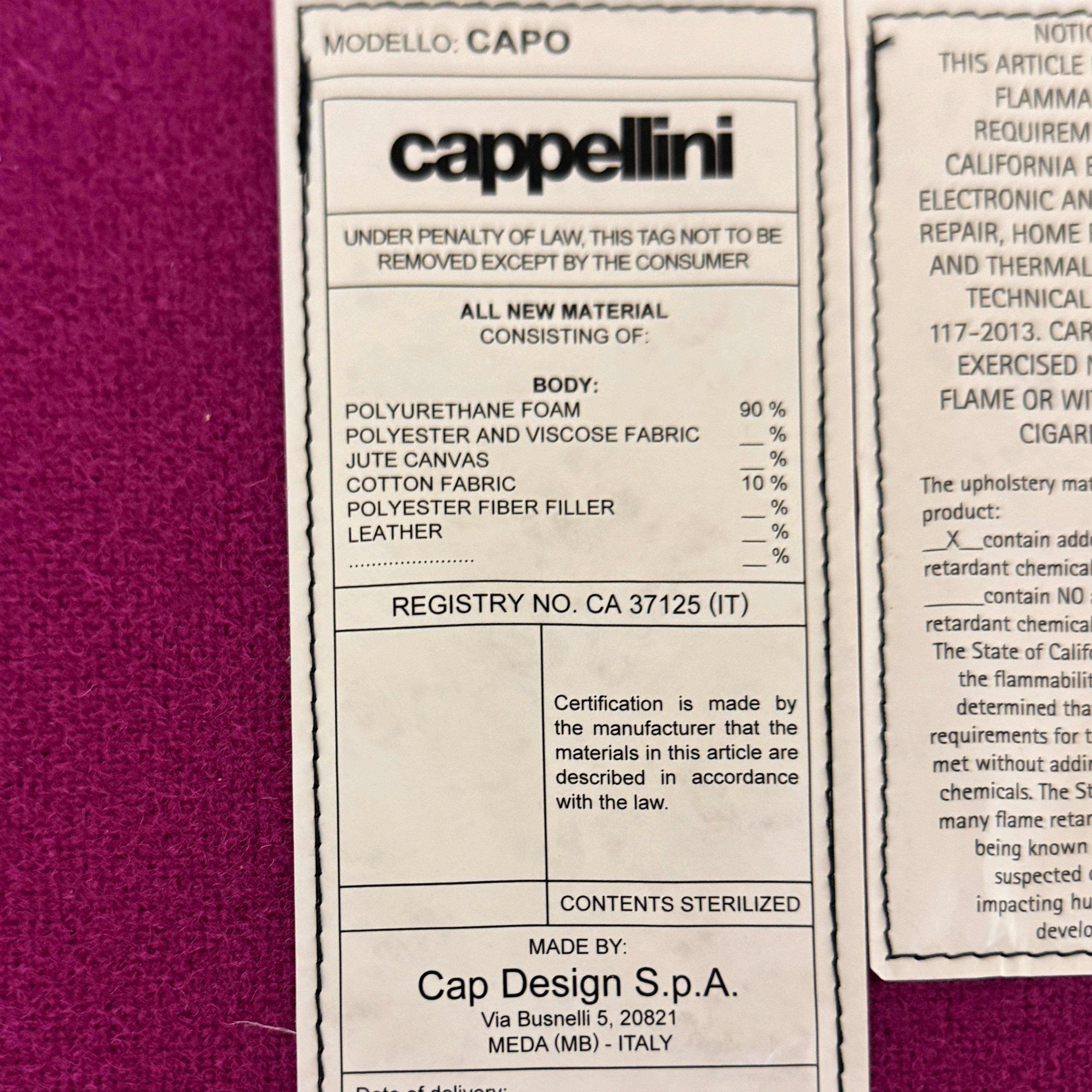 The Cappellini Capo Chair by Cappellini features a modern design with bright magenta upholstery, an angular backrest, and white metal legs, set against a plain white background.