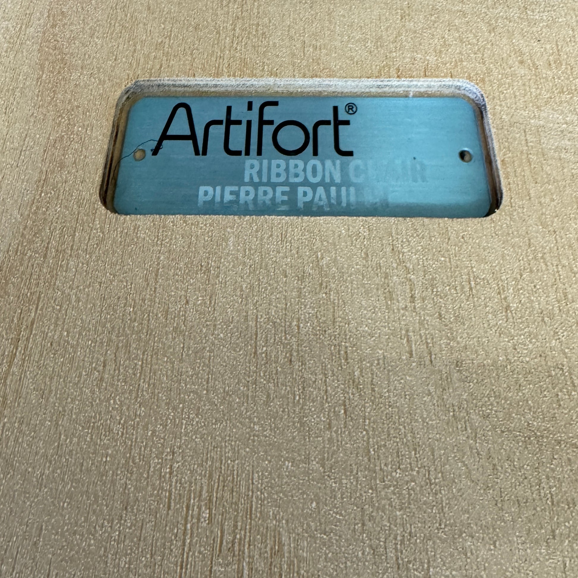 The Artifort Ribbon Lounge Chair & Ottoman by Artifort features a modern blue design with a sculptural curved backrest and split seat on a white base, seen here against a plain white background.