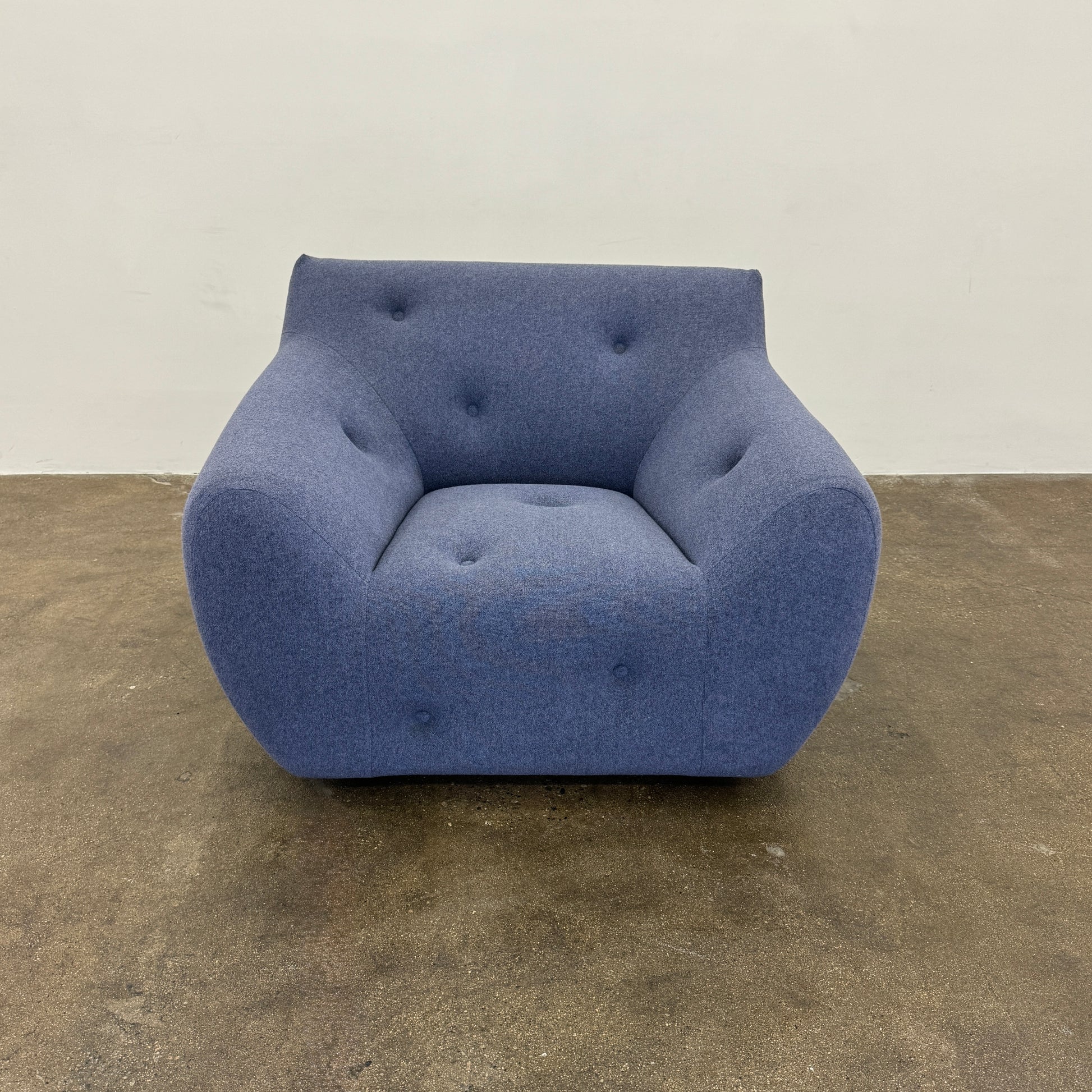 The Roche Bobois Informel Outdoor Armchair Low Back - Bleuet is a modern blue armchair with tufted buttons and plush comfort, shown against a white background.