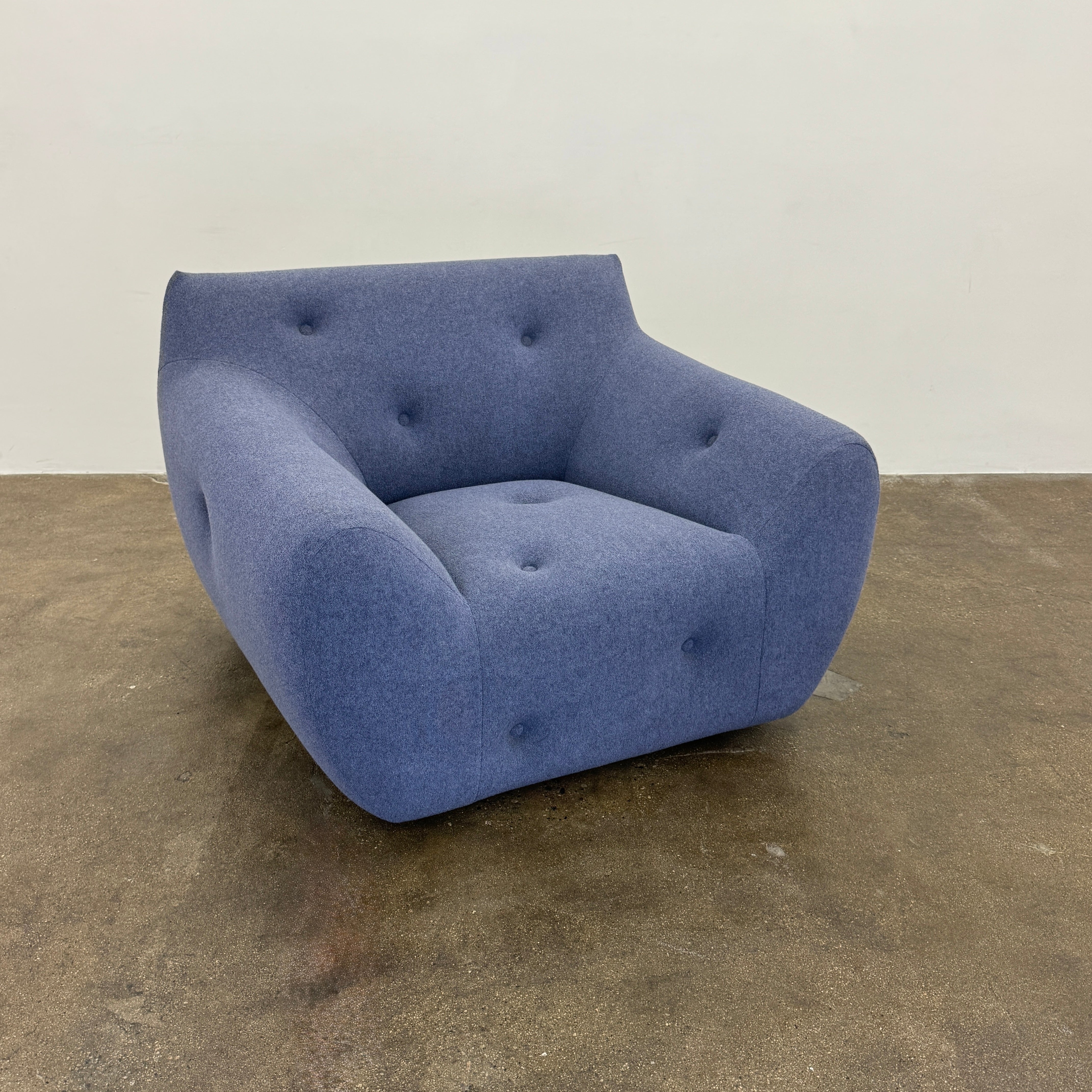 The Roche Bobois Informel Outdoor Armchair Low Back - Bleuet is a modern blue armchair with tufted buttons and plush comfort, shown against a white background.