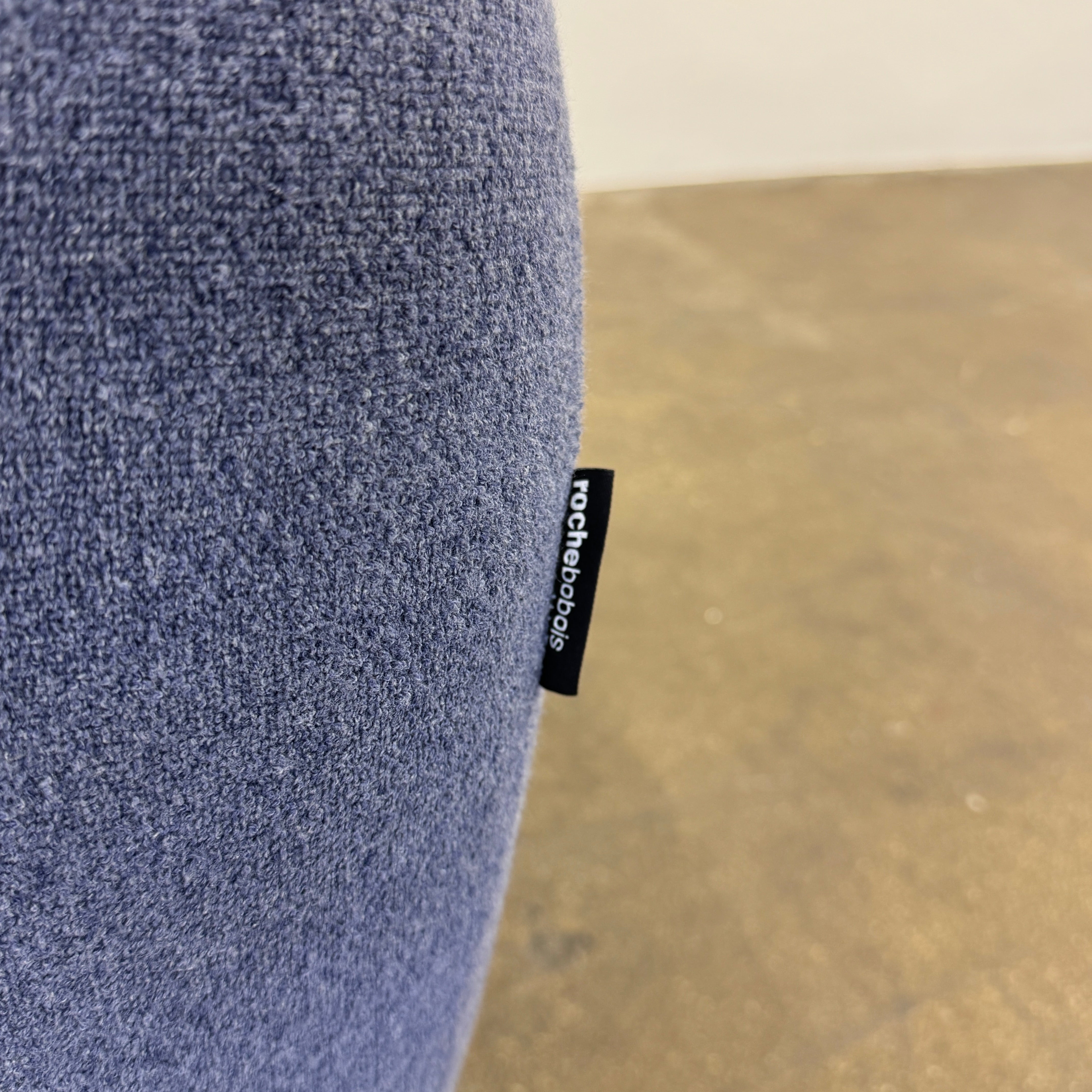 The Roche Bobois Informel Outdoor Armchair Low Back - Bleuet is a modern blue armchair with tufted buttons and plush comfort, shown against a white background.