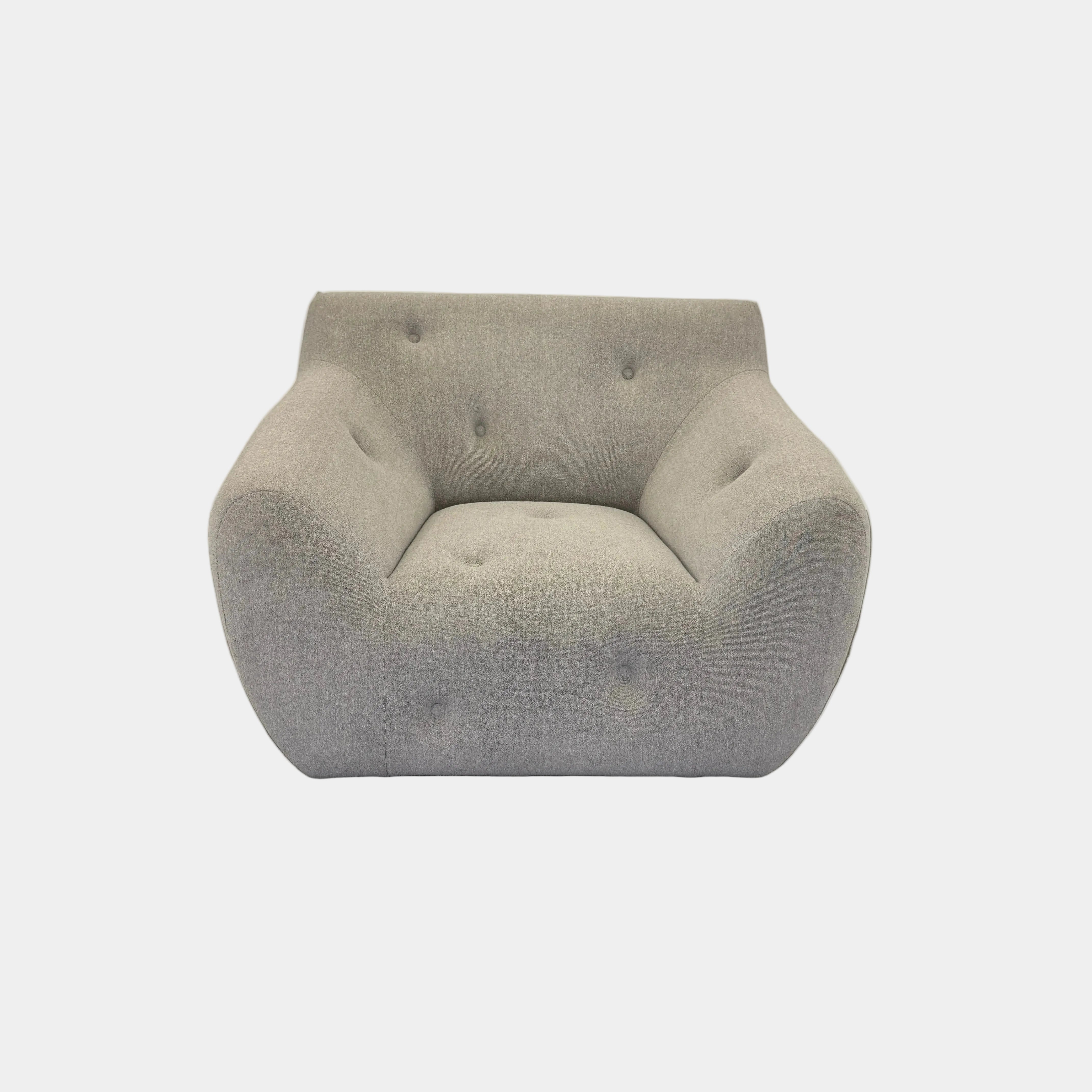 The Roche Bobois Informel Outdoor Low Back Armchair by Roche Bobois features modern, light gray upholstery with rounded arms and tufted button details for plush comfort, shown from the front on a white background.
