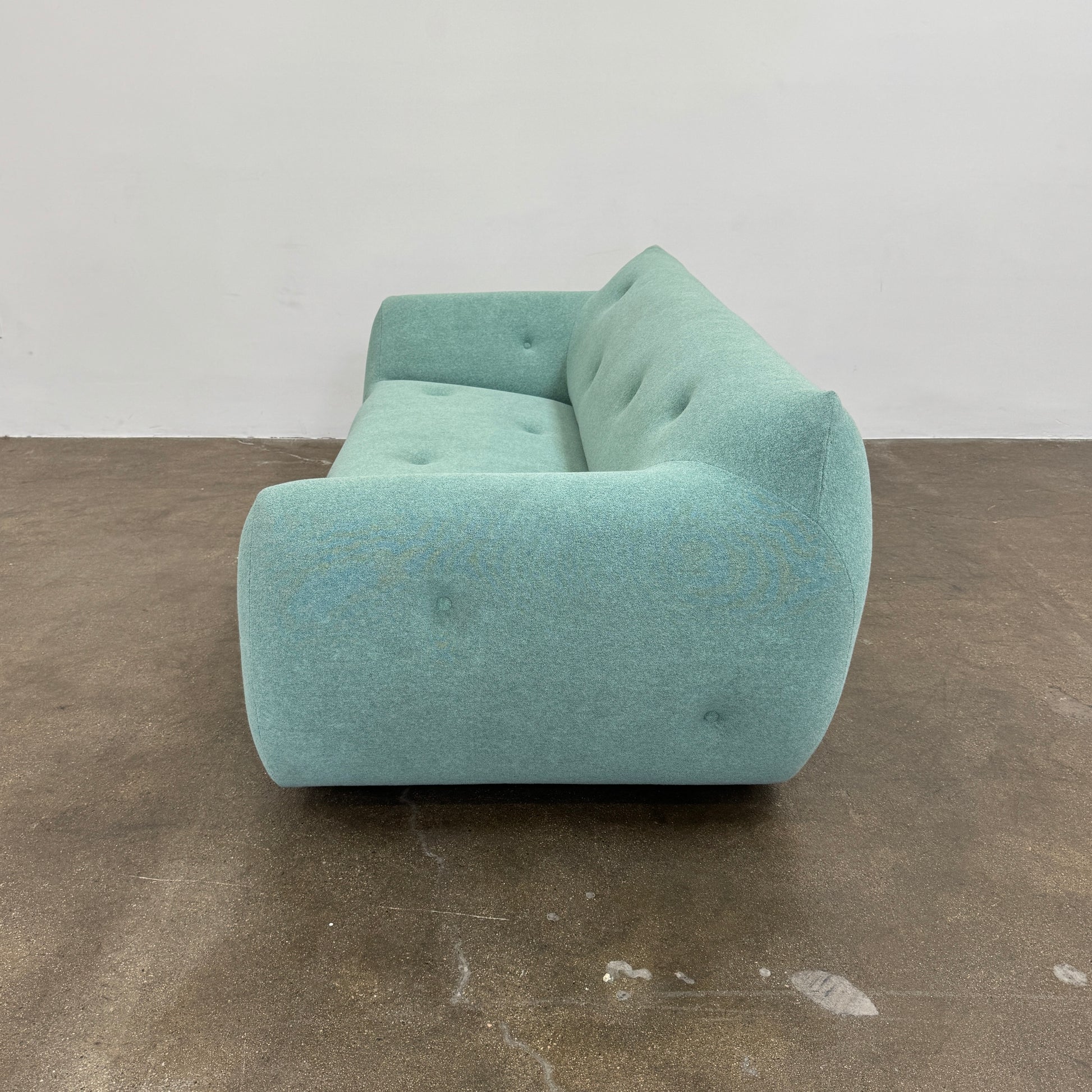 The Roche Bobois Informel Outdoor Large 3-seat Sofa Low Back features a light teal modern design with rounded edges, button-tufted details, and advanced outdoor fabric technology, inspired by Roche Bobois’s signature style.