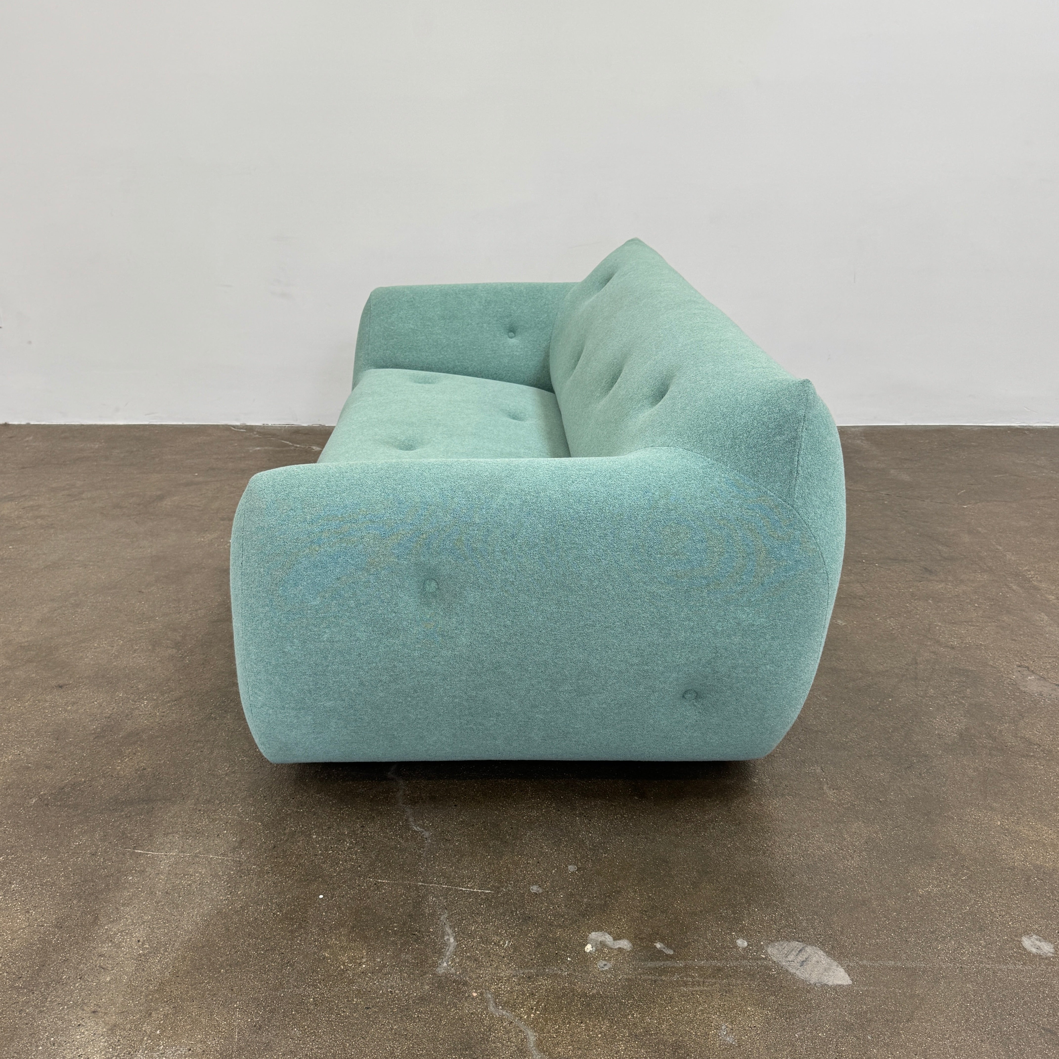 The Roche Bobois Informel Outdoor Large 3-seat Sofa Low Back features a light teal modern design with rounded edges, button-tufted details, and advanced outdoor fabric technology, inspired by Roche Bobois’s signature style.