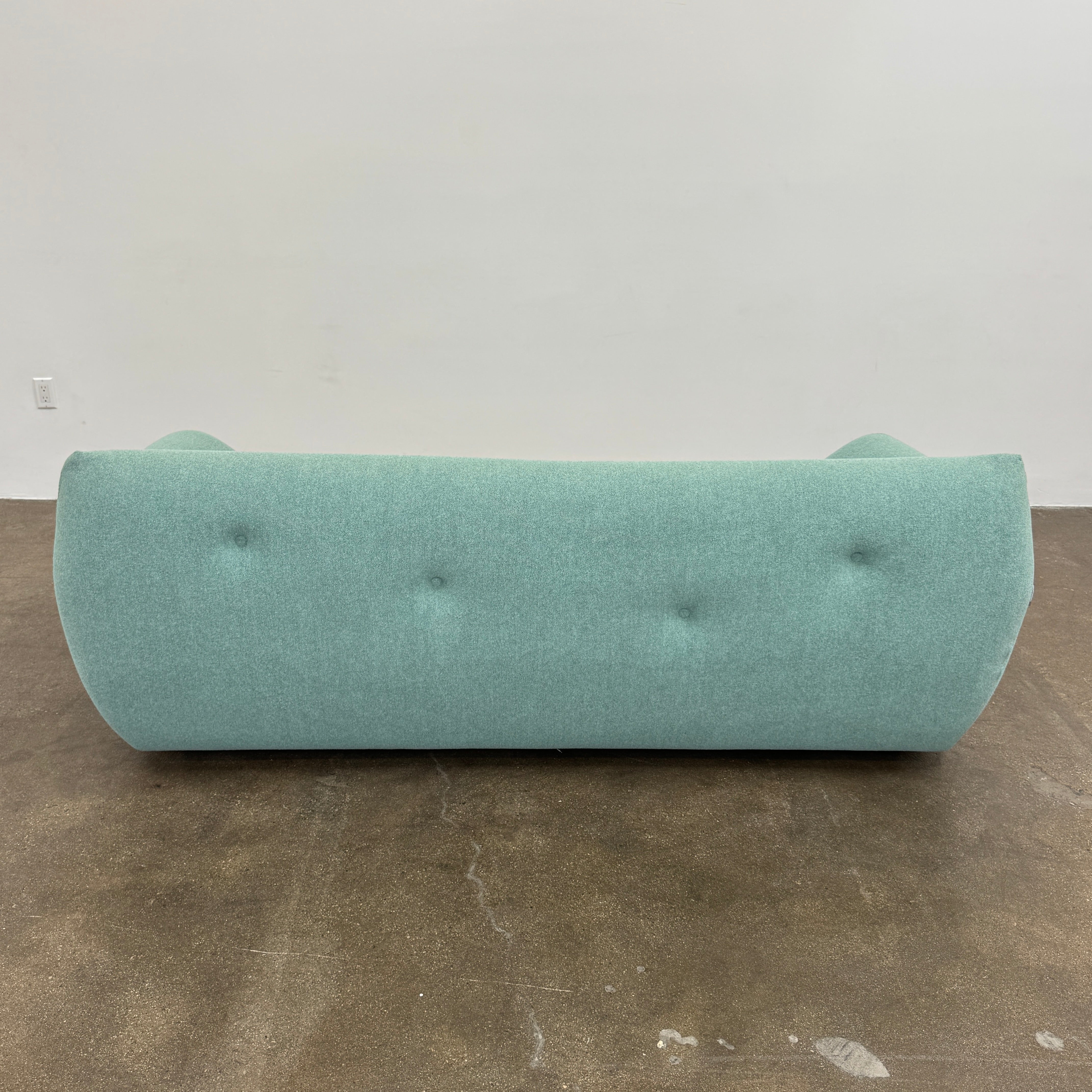 The Roche Bobois Informel Outdoor Large 3-seat Sofa Low Back features a light teal modern design with rounded edges, button-tufted details, and advanced outdoor fabric technology, inspired by Roche Bobois’s signature style.