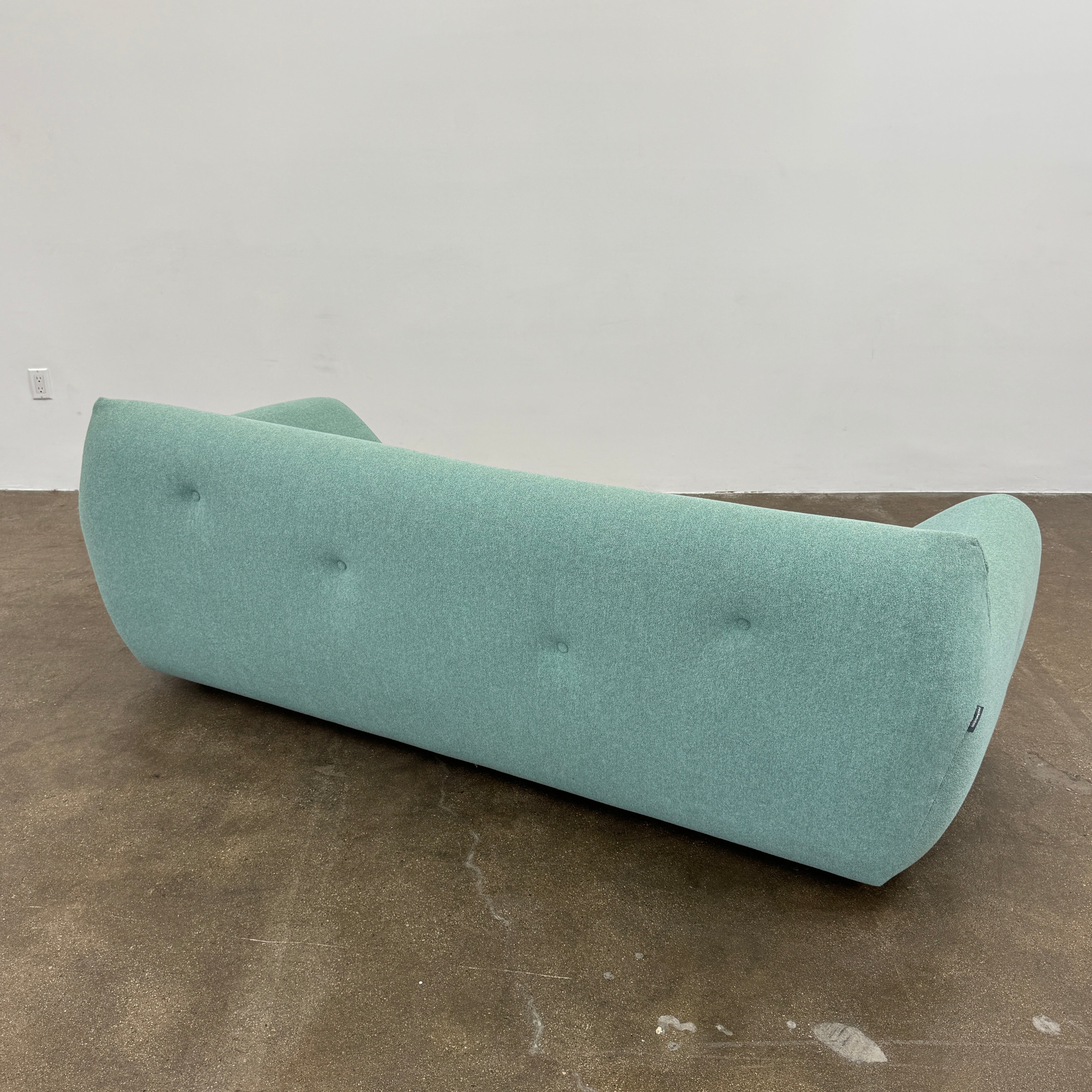 The Roche Bobois Informel Outdoor Large 3-seat Sofa Low Back features a light teal modern design with rounded edges, button-tufted details, and advanced outdoor fabric technology, inspired by Roche Bobois’s signature style.