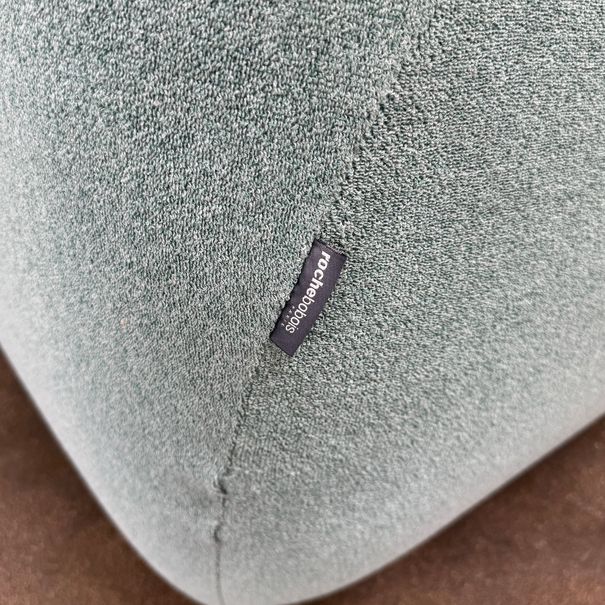 The Roche Bobois Informel Outdoor Large 3-seat Sofa Low Back features a light teal modern design with rounded edges, button-tufted details, and advanced outdoor fabric technology, inspired by Roche Bobois’s signature style.