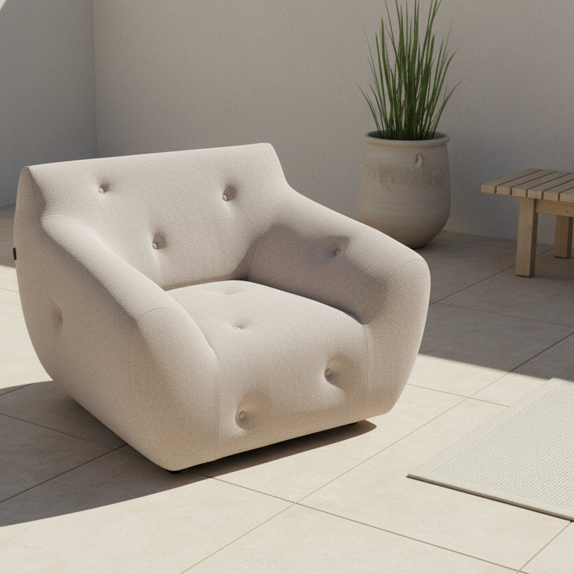 The Roche Bobois Informel Outdoor Low Back Armchair by Roche Bobois features modern, light gray upholstery with rounded arms and tufted button details for plush comfort, shown from the front on a white background.