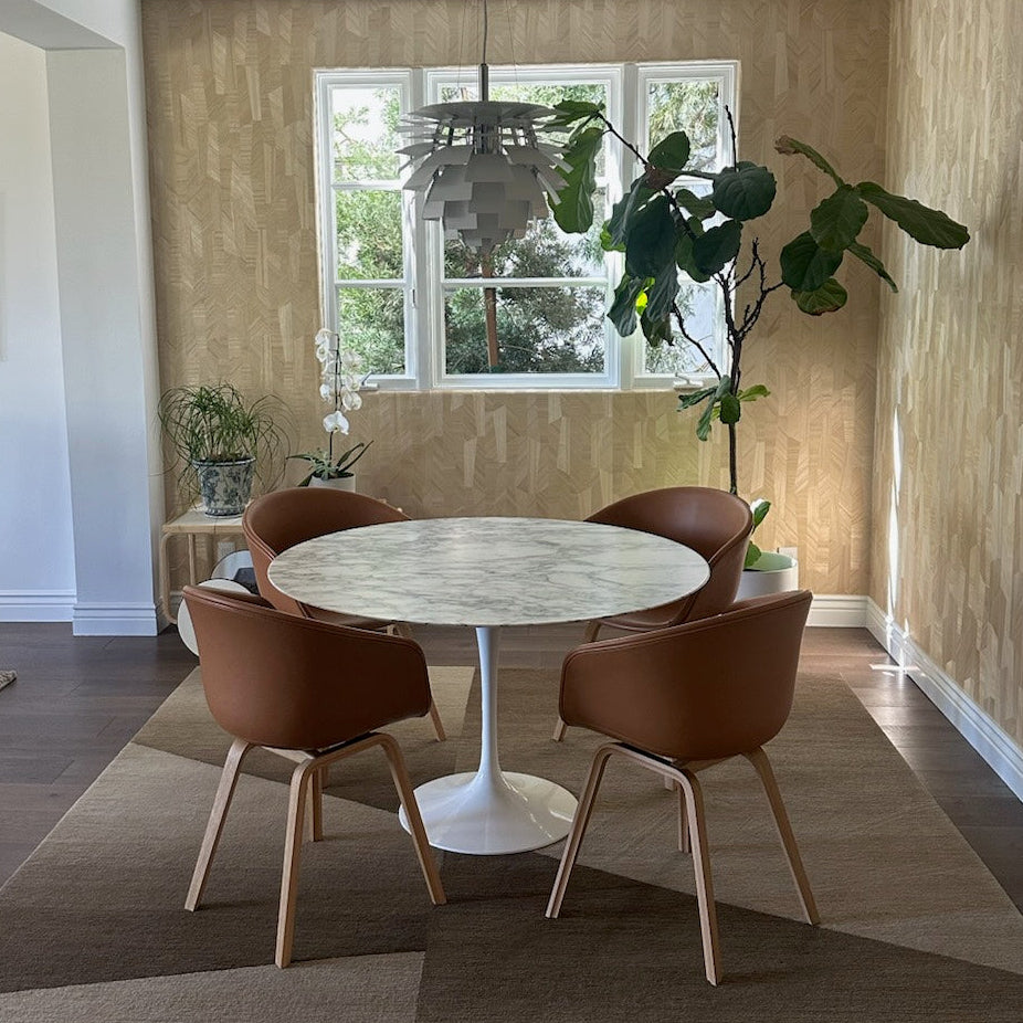 The Louis Poulsen PH Artichoke Suspension Light by Louis Poulsen features layered, overlapping white panels in a spherical form, inspired by the iconic PH Artichoke Lamp and suspended from a ceiling cord.