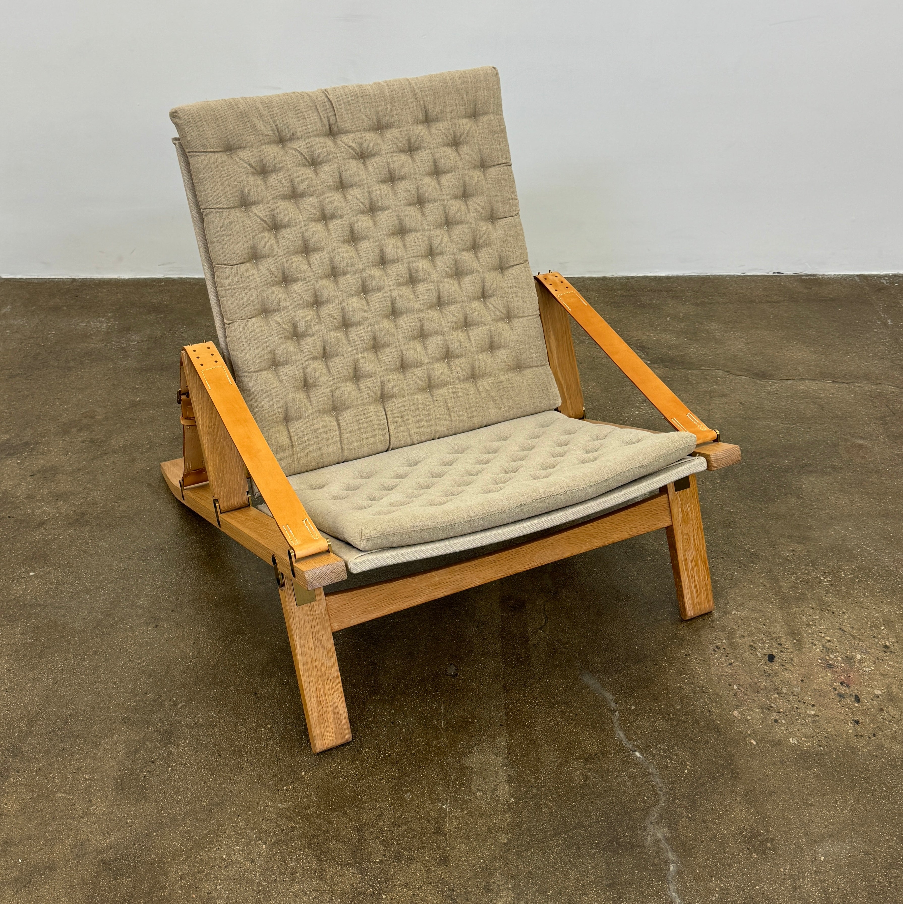 Front view of the Carl Hansen & Son FK11 Pilco Lounge Chair, a Danish design with light brown tufted upholstery on the backrest and seat cushion, by Carl Hansen & Son, isolated on a white background.