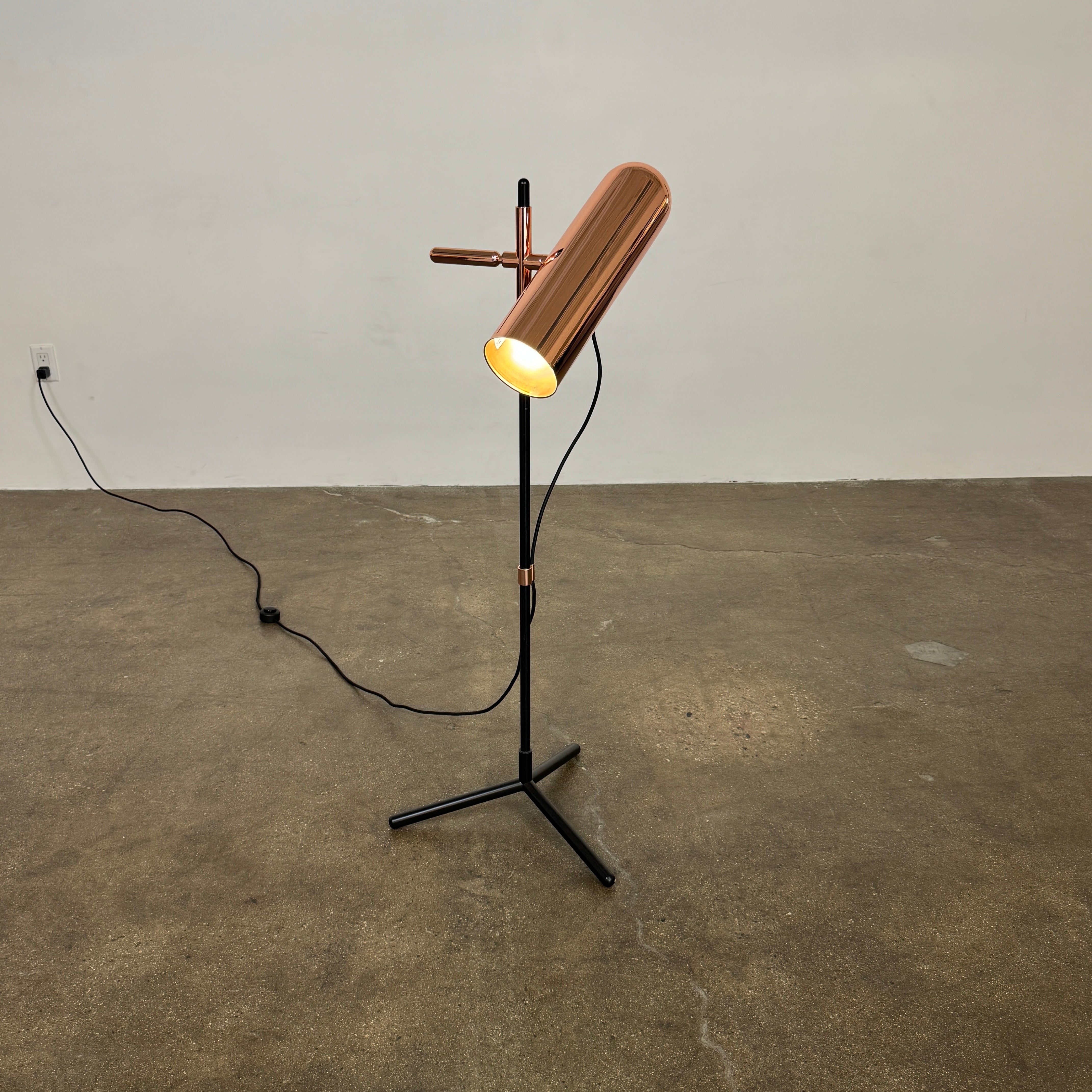 The Roche Bobois Wander Floor lamp features a cylindrical copper shade, black stand, and tripod base with attached power cord—an elegant, modern addition inspired by Roche Bobois design.