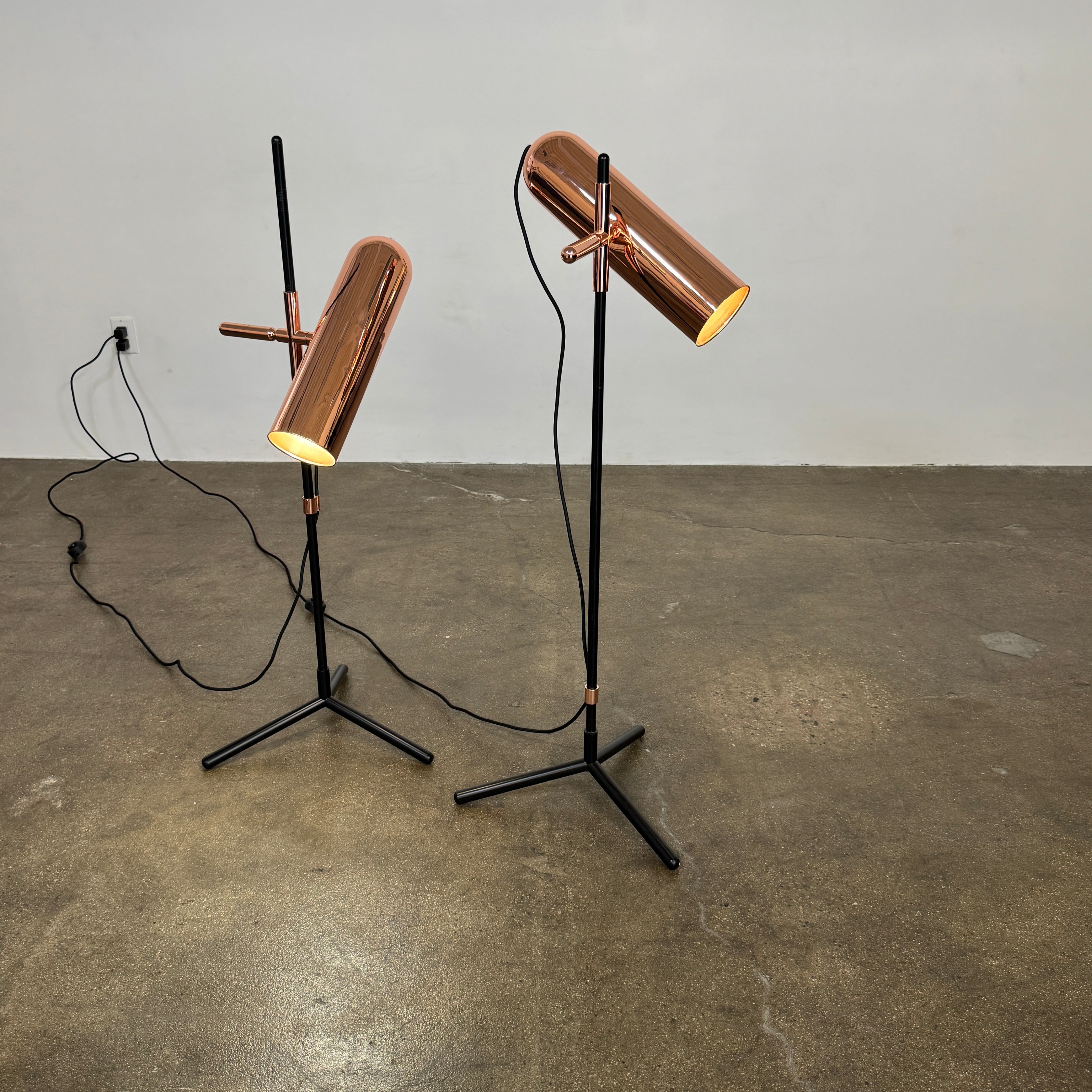 The Roche Bobois Wander Floor lamp features a cylindrical copper shade, black stand, and tripod base with attached power cord—an elegant, modern addition inspired by Roche Bobois design.