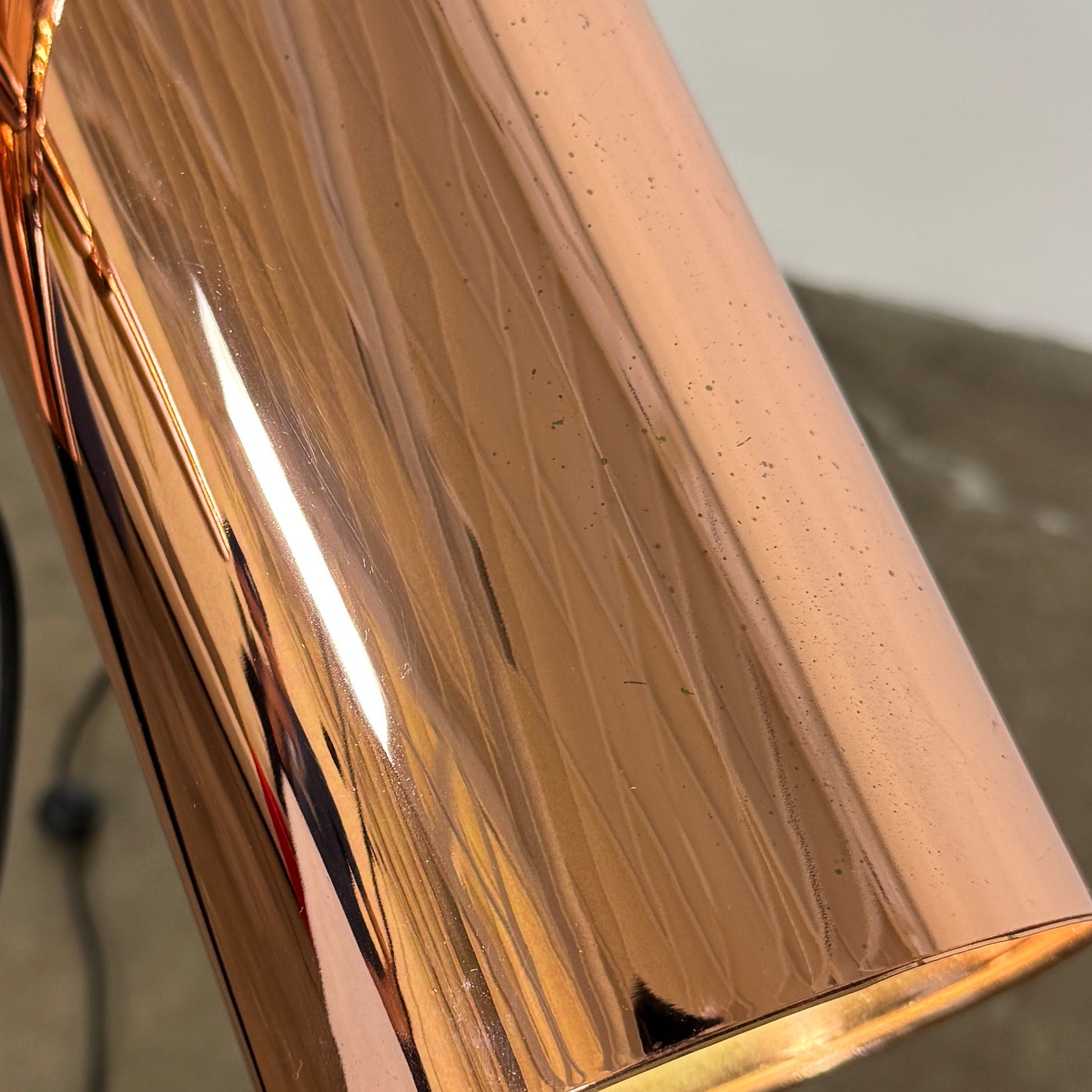 The Roche Bobois Wander Floor lamp features a cylindrical copper shade, black stand, and tripod base with attached power cord—an elegant, modern addition inspired by Roche Bobois design.