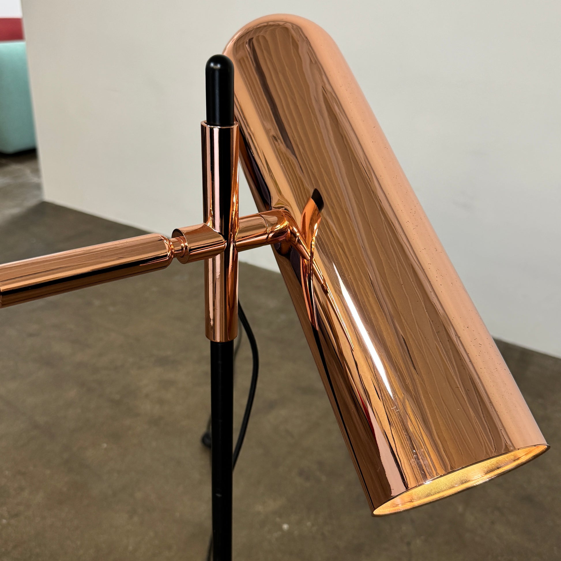 The Roche Bobois Wander Floor lamp features a cylindrical copper shade, black stand, and tripod base with attached power cord—an elegant, modern addition inspired by Roche Bobois design.