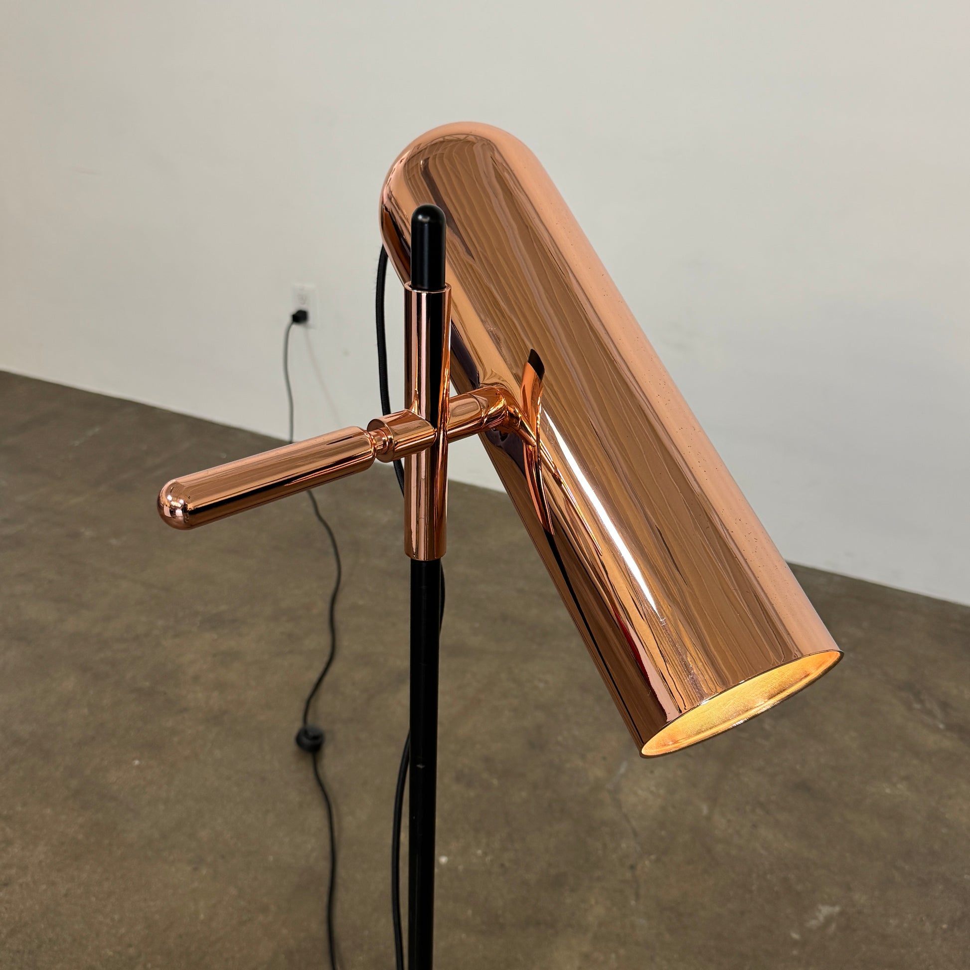 The Roche Bobois Wander Floor lamp features a cylindrical copper shade, black stand, and tripod base with attached power cord—an elegant, modern addition inspired by Roche Bobois design.