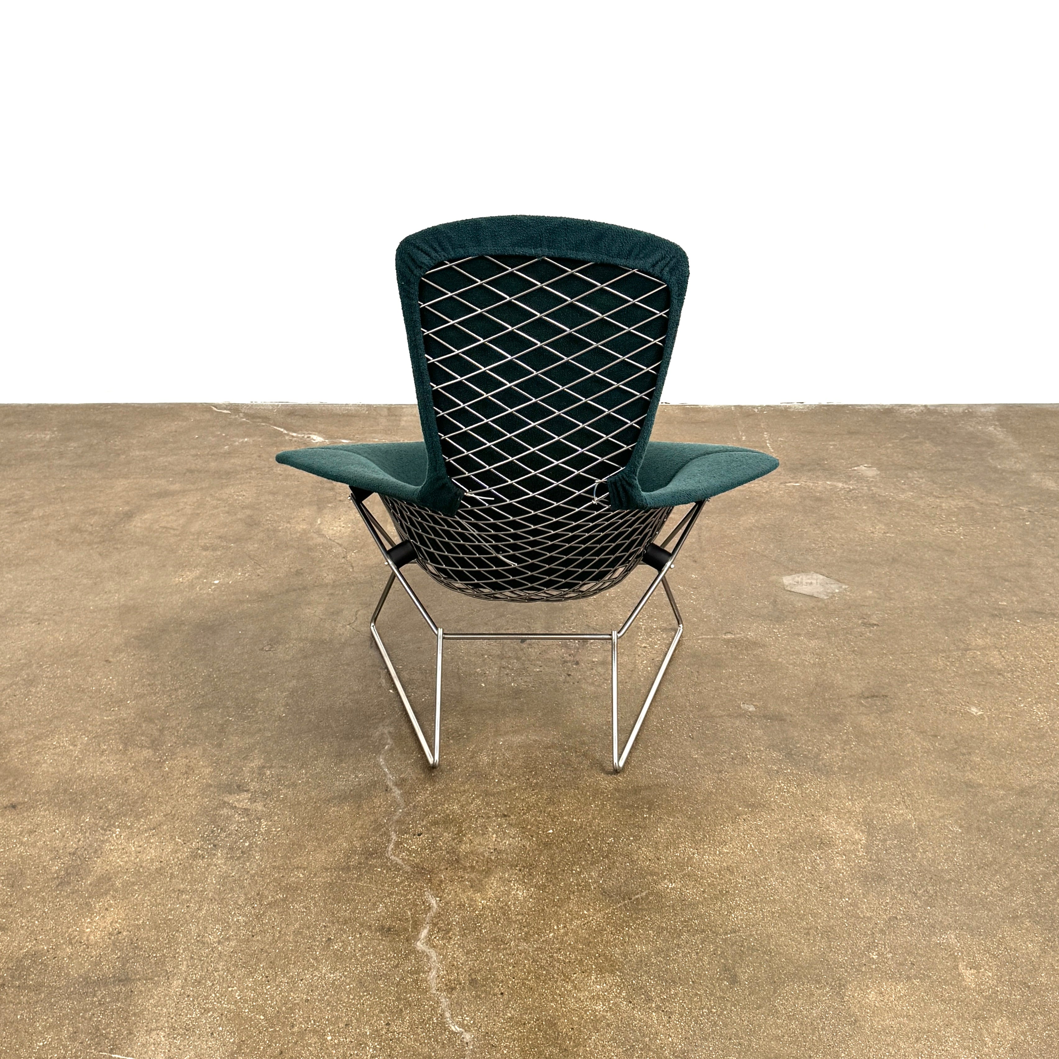 The Vintage Bertoia Bird Chair by Vintage features a modern green upholstered design with a curved backrest and metal wire base, inspired by mid-century style, photographed against a plain white background.