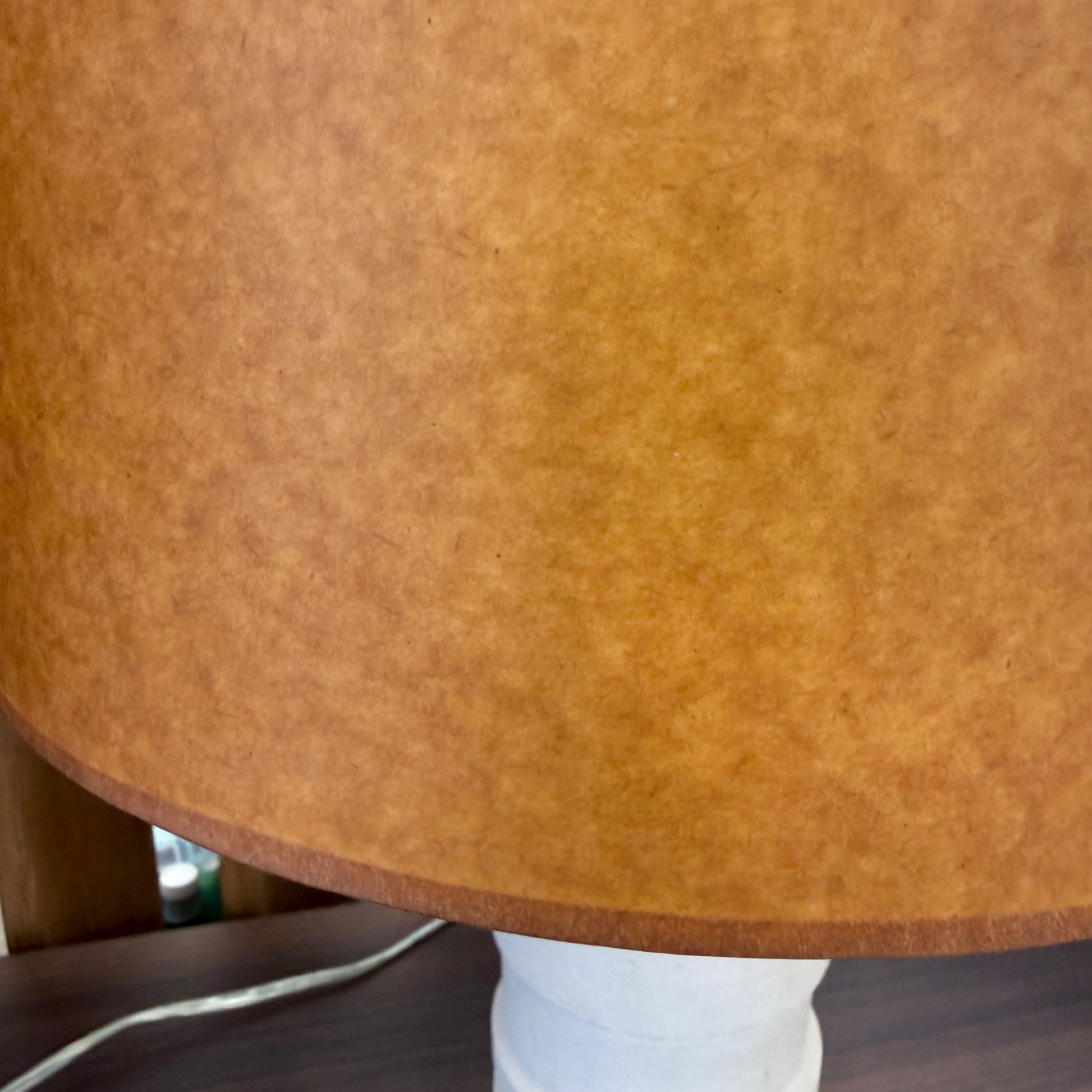 Two Shelter Brasilia Lamp by Modern Resale with textured white bases and orange cylindrical shades are displayed on a beige stone surface against a gray background.