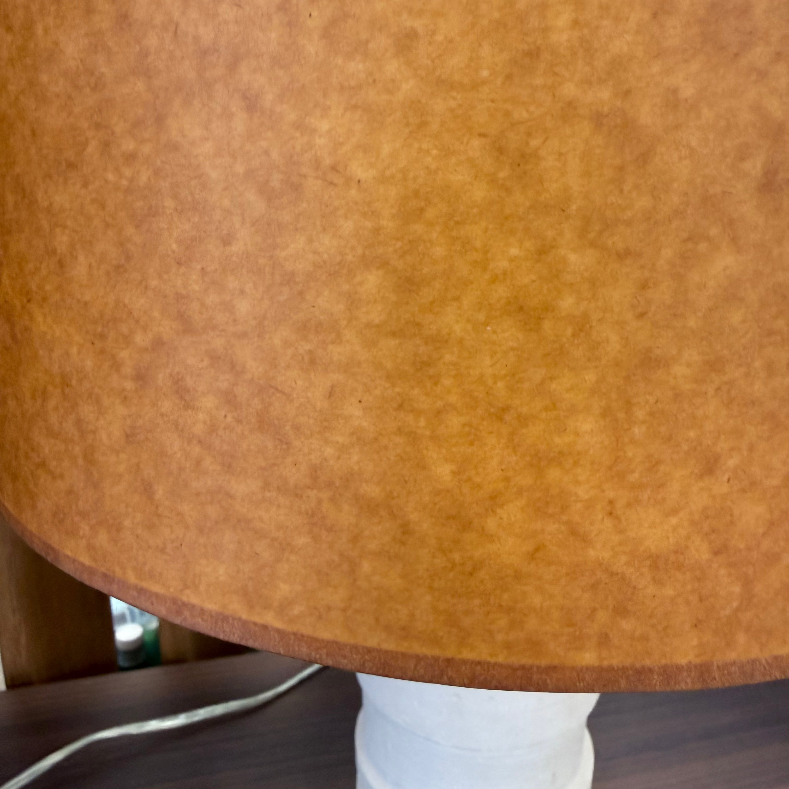 Two Shelter Brasilia Lamp by Modern Resale with textured white bases and orange cylindrical shades are displayed on a beige stone surface against a gray background.