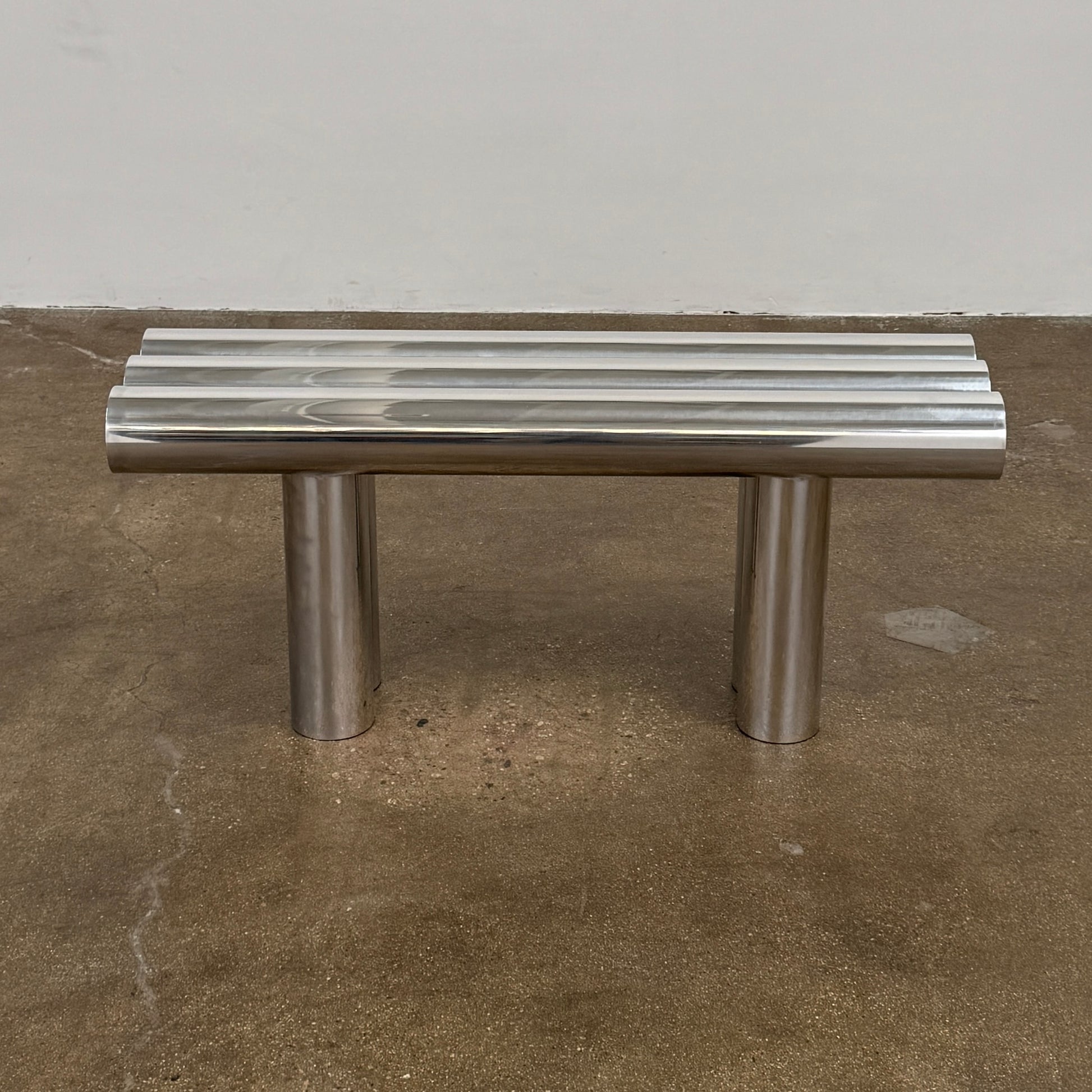 The Future Perfect's Septem Bench by Axel Chay features three cylindrical polished metal seats and matching legs in a Mediterranean-inspired design, shown against a plain white background.