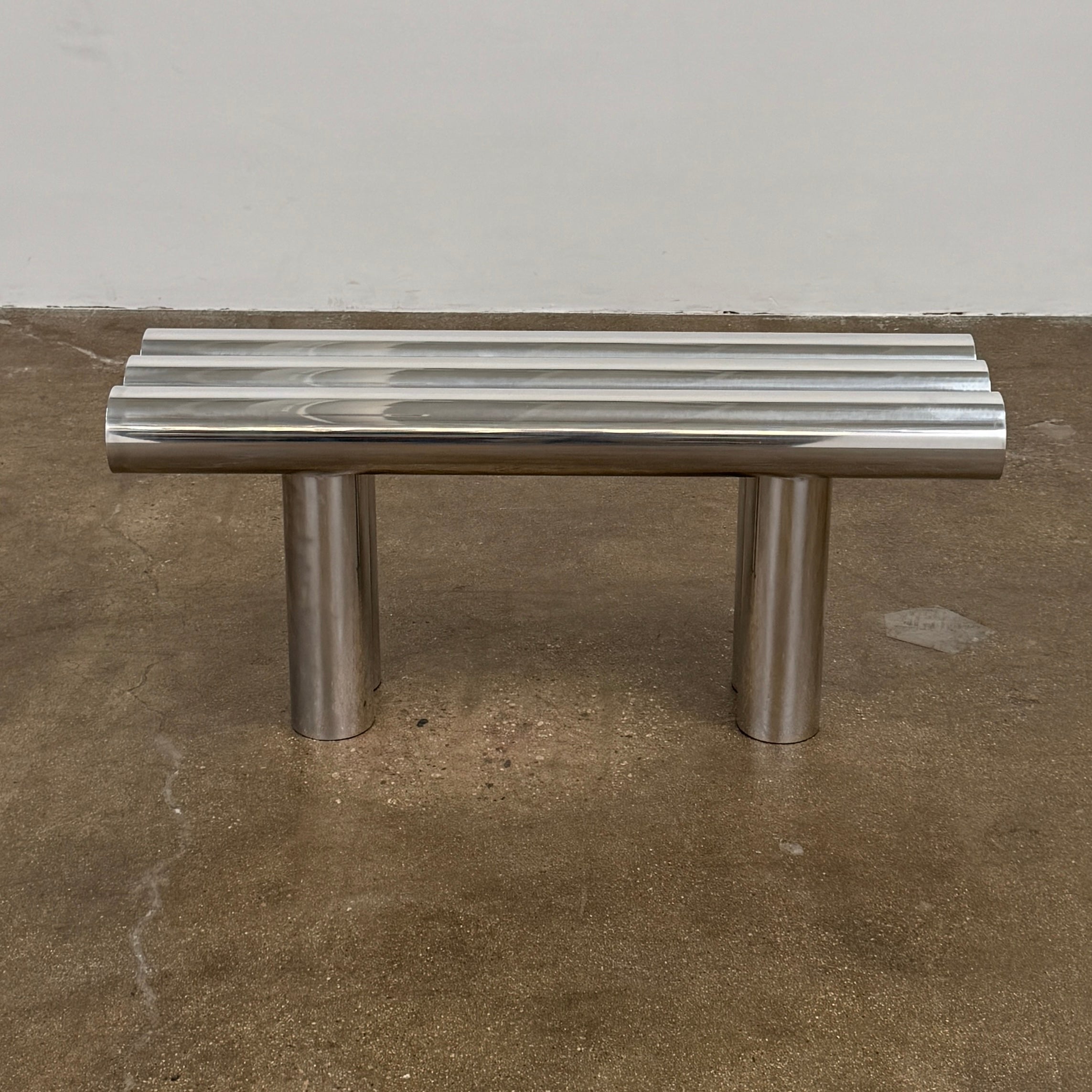 The Future Perfect's Septem Bench by Axel Chay features three cylindrical polished metal seats and matching legs in a Mediterranean-inspired design, shown against a plain white background.