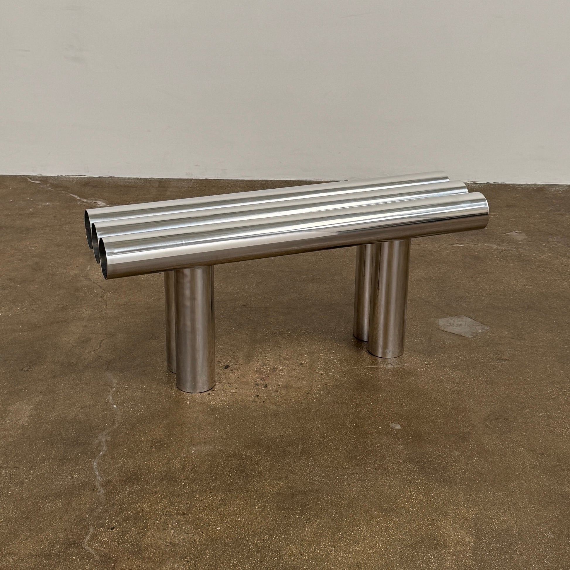 The Future Perfect's Septem Bench by Axel Chay features three cylindrical polished metal seats and matching legs in a Mediterranean-inspired design, shown against a plain white background.