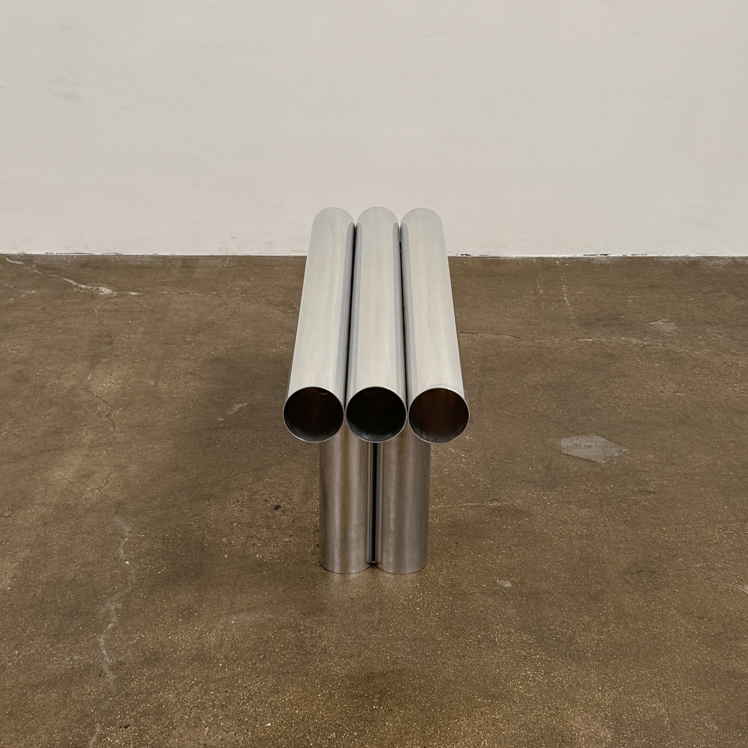 The Future Perfect's Septem Bench by Axel Chay features three cylindrical polished metal seats and matching legs in a Mediterranean-inspired design, shown against a plain white background.