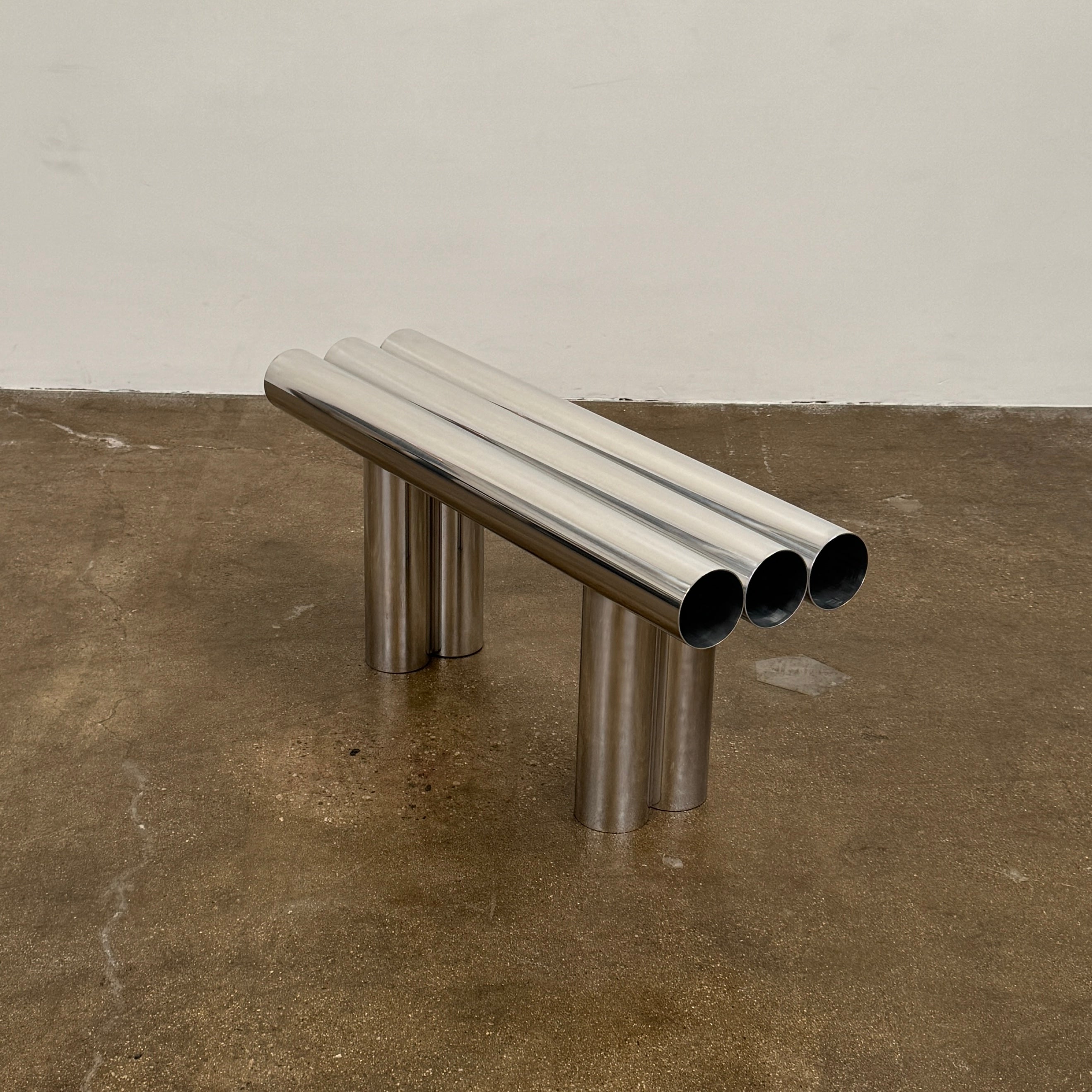 The Future Perfect's Septem Bench by Axel Chay features three cylindrical polished metal seats and matching legs in a Mediterranean-inspired design, shown against a plain white background.