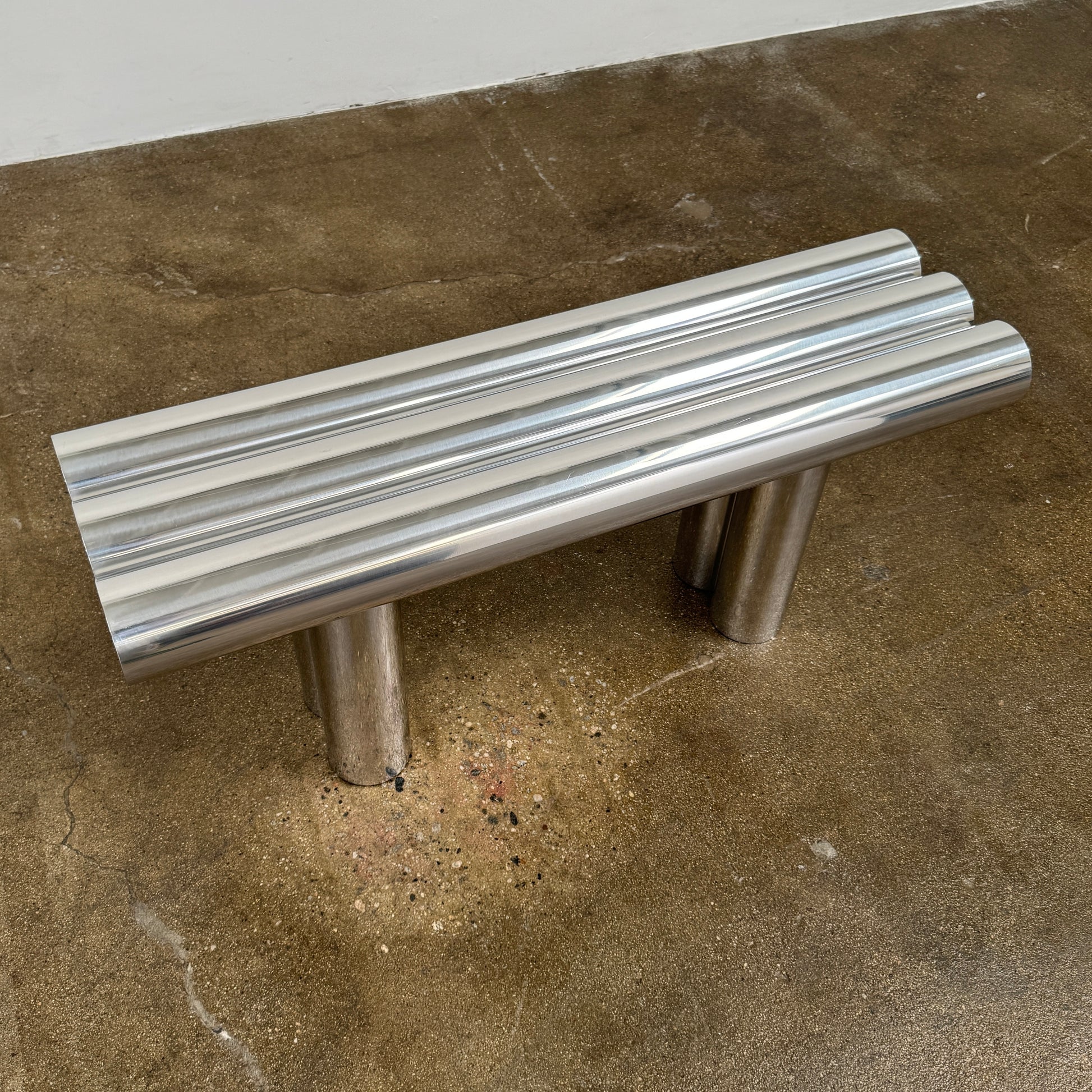 The Future Perfect's Septem Bench by Axel Chay features three cylindrical polished metal seats and matching legs in a Mediterranean-inspired design, shown against a plain white background.