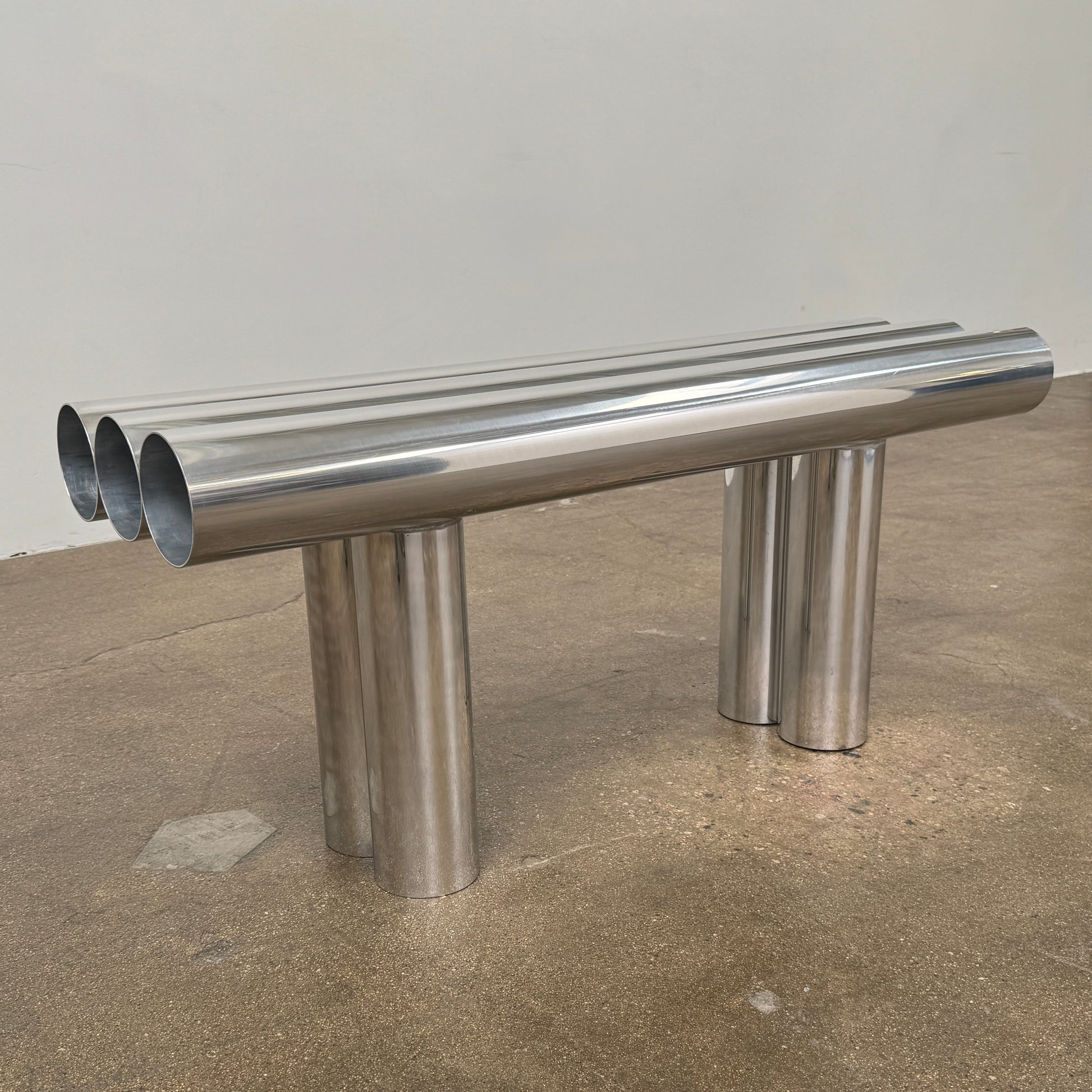 The Future Perfect's Septem Bench by Axel Chay features three cylindrical polished metal seats and matching legs in a Mediterranean-inspired design, shown against a plain white background.