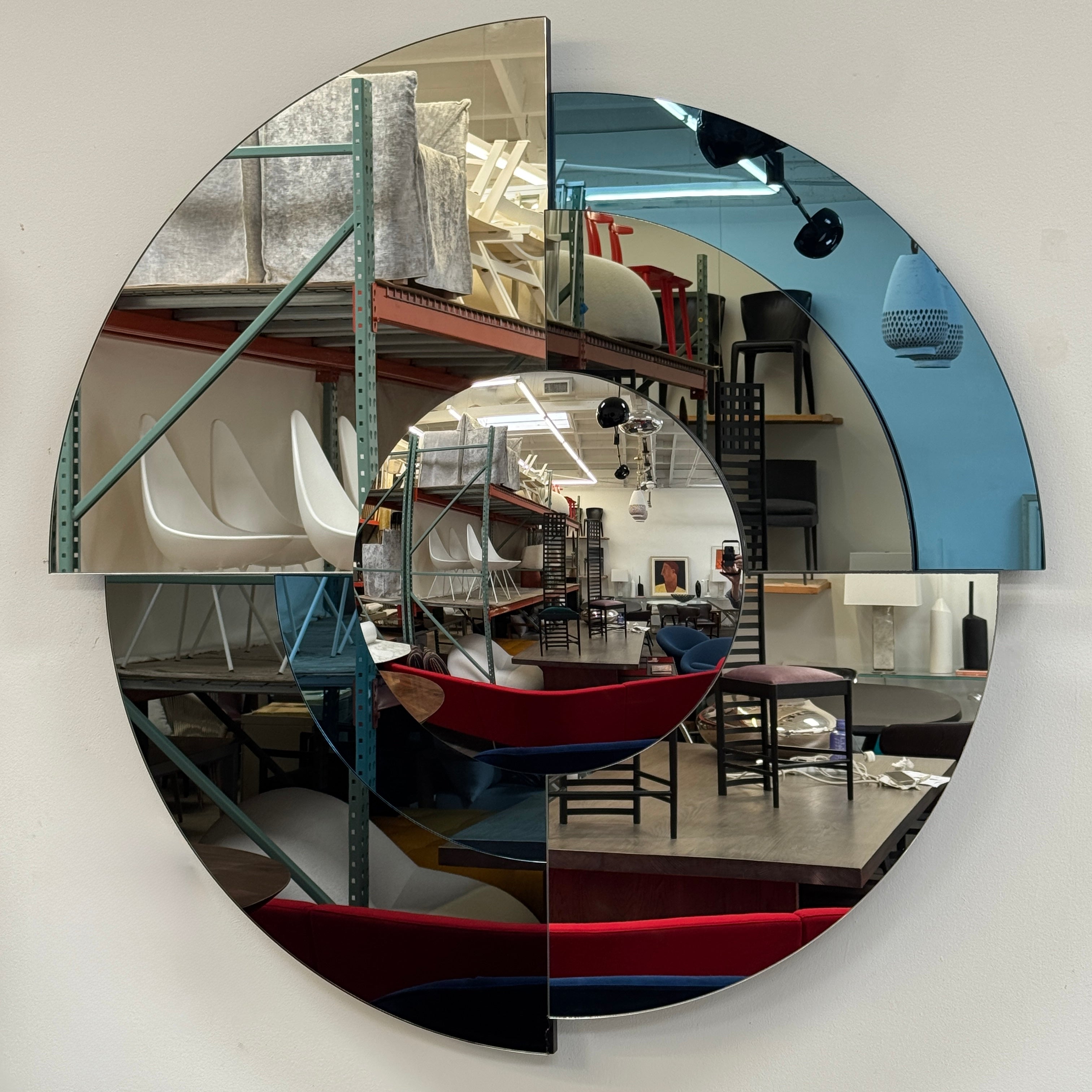 The Roche Bobois Merlin Mirror - Smoked gray / Blue features round geometric segments, making it a striking statement wall mirror from Roche Bobois.