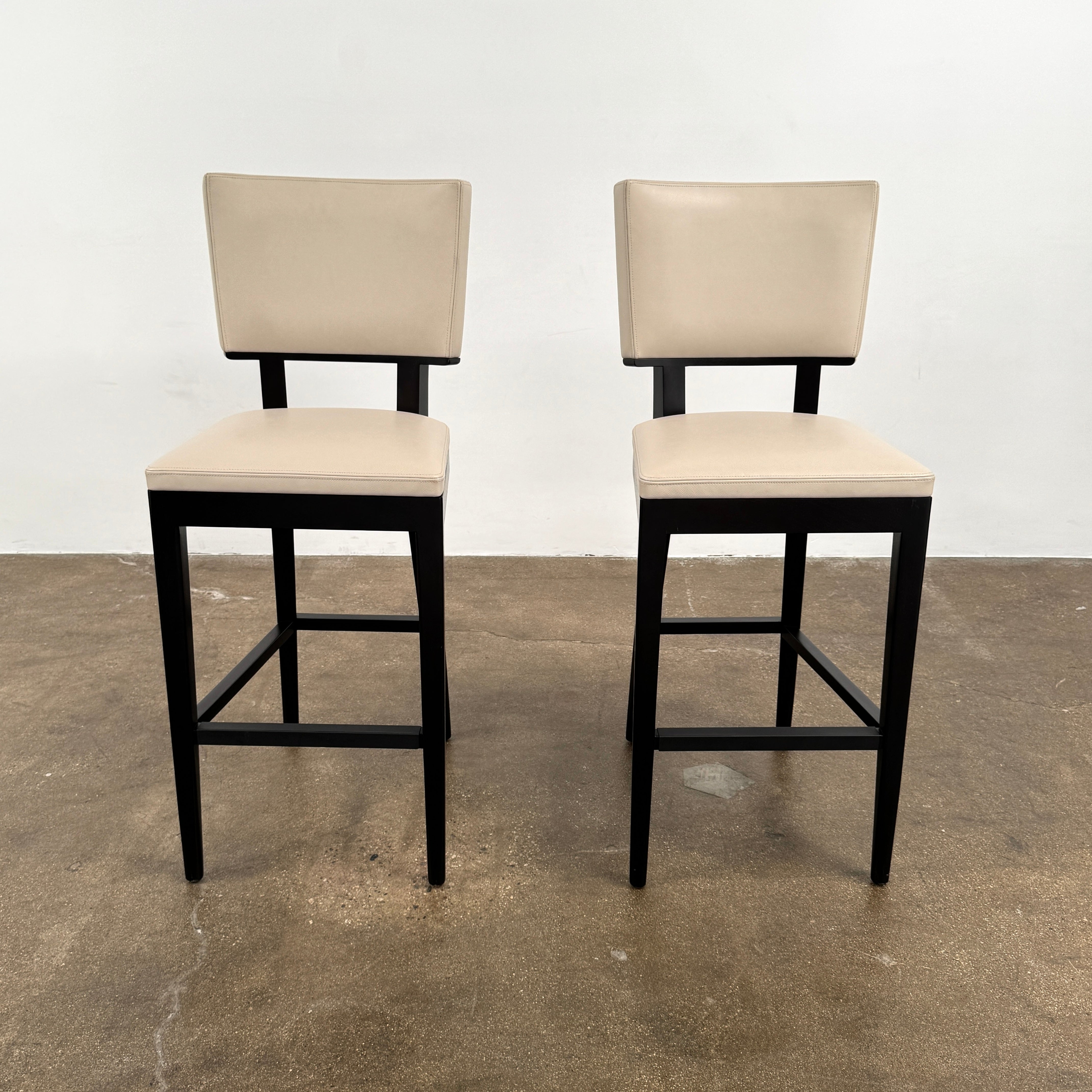 Modern kitchen featuring a minimalist luxury vibe—Christian Liagre Bar Stool Set of 2 at the counter, large windows draped with sheer white curtains, and a stunning cityscape view outside.